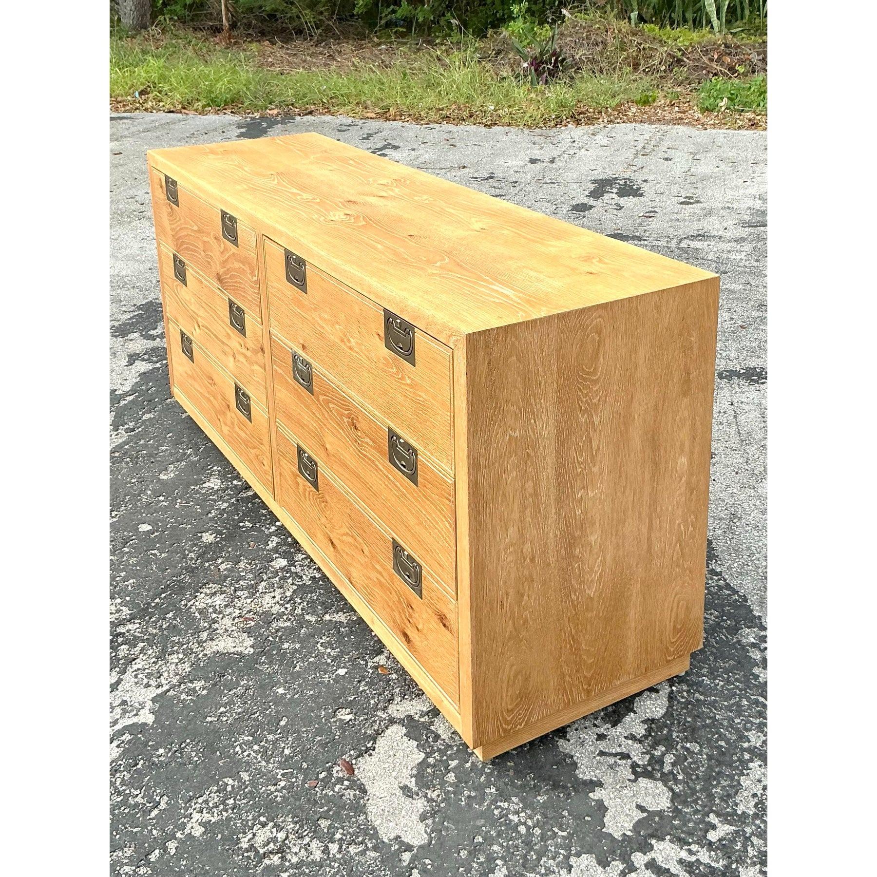 This stunning vintage Henredon Bel Aire dresser exudes natural elegance with its washed wood finish and classic campaign-style brass hardware. The clean lines and warm wood grain bring a timeless appeal, making it a perfect addition to bohemian,