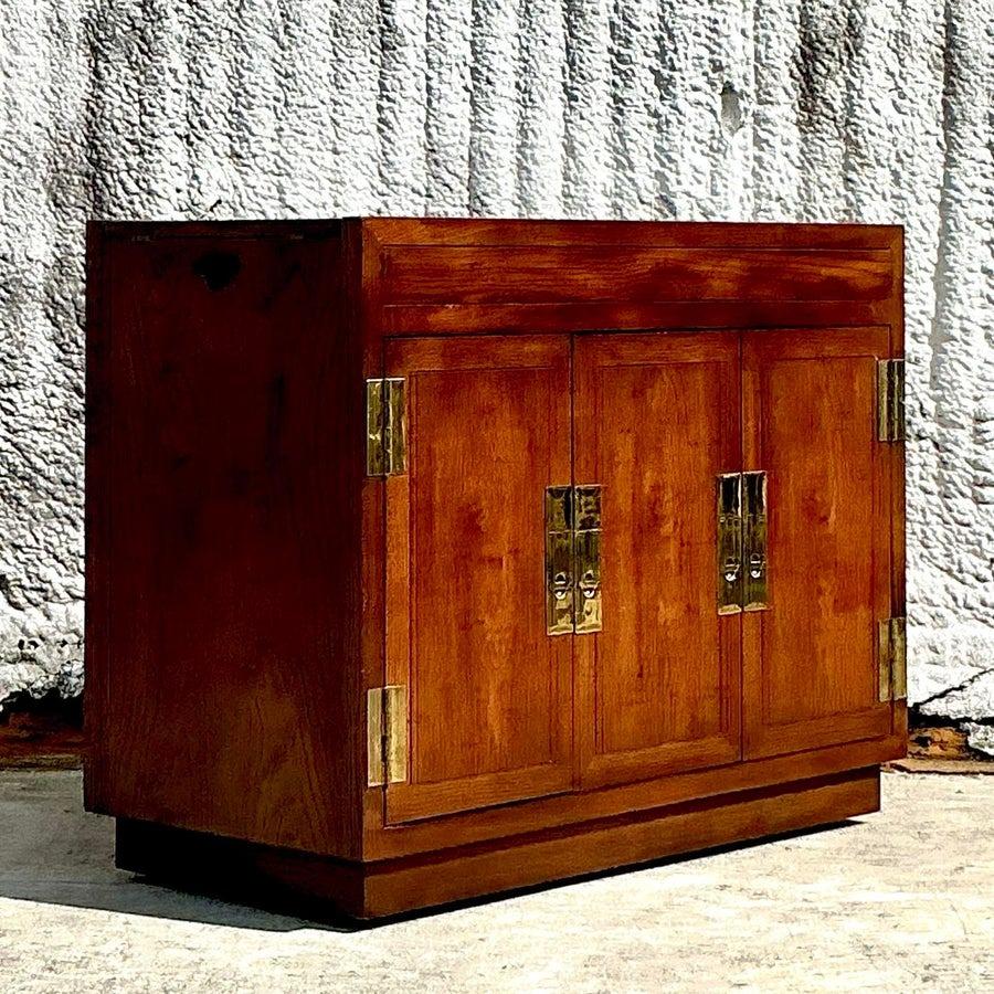 Eleva tu salón o comedor con esta impresionante barra seca vintage Henredon Campaign. Con un diseño elegante y compacto, esta pieza está fabricada en madera noble y acentuada con elegantes herrajes de latón. Su diseño versátil incluye paneles