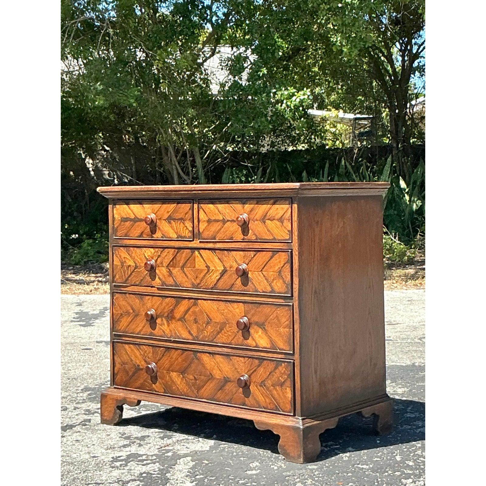 Questa squisita cassettiera vintage a spina di pesce è un mix perfetto di fascino bohémien e artigianato classico. L'intarsio del legno presenta uno splendido disegno a spina di pesce, che aggiunge profondità e consistenza alla sua finitura ricca e
