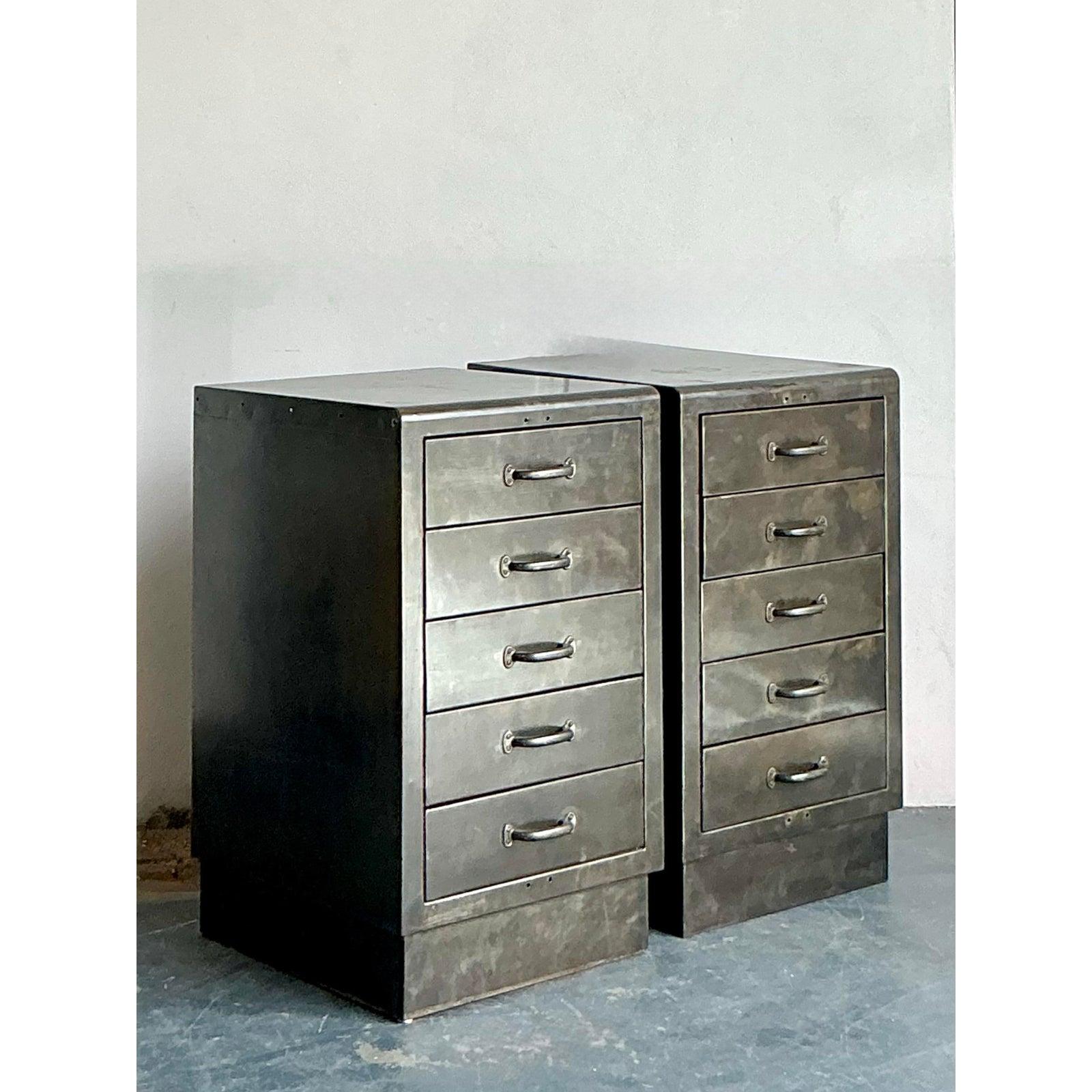 Inject raw character and functional design into your space with this impressive pair of vintage industrial metal filing chests, perfect for a Boho Chic aesthetic with an edge. Each chest is crafted from robust metal, featuring a distinctive dark,
