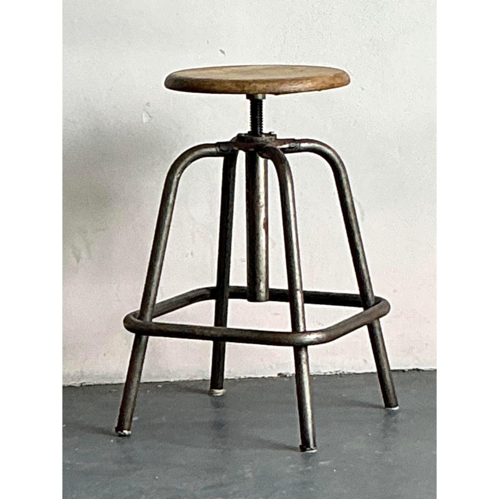 Inject authentic character and versatile utility into your space with this vintage industrial stool, a perfect blend of robust design and Boho Chic appeal. This classic workshop-style stool features a sturdy metal base with a square footrest,