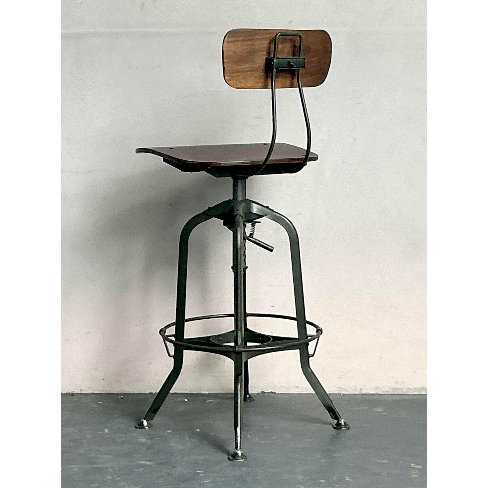Embrace the robust charm of this vintage Boho Industrial Adjustable Swivel Stool, a perfect blend of utilitarian design and eclectic style. Featuring a warm wooden seat and backrest contrasted with a sturdy dark metal base, this stool embodies an