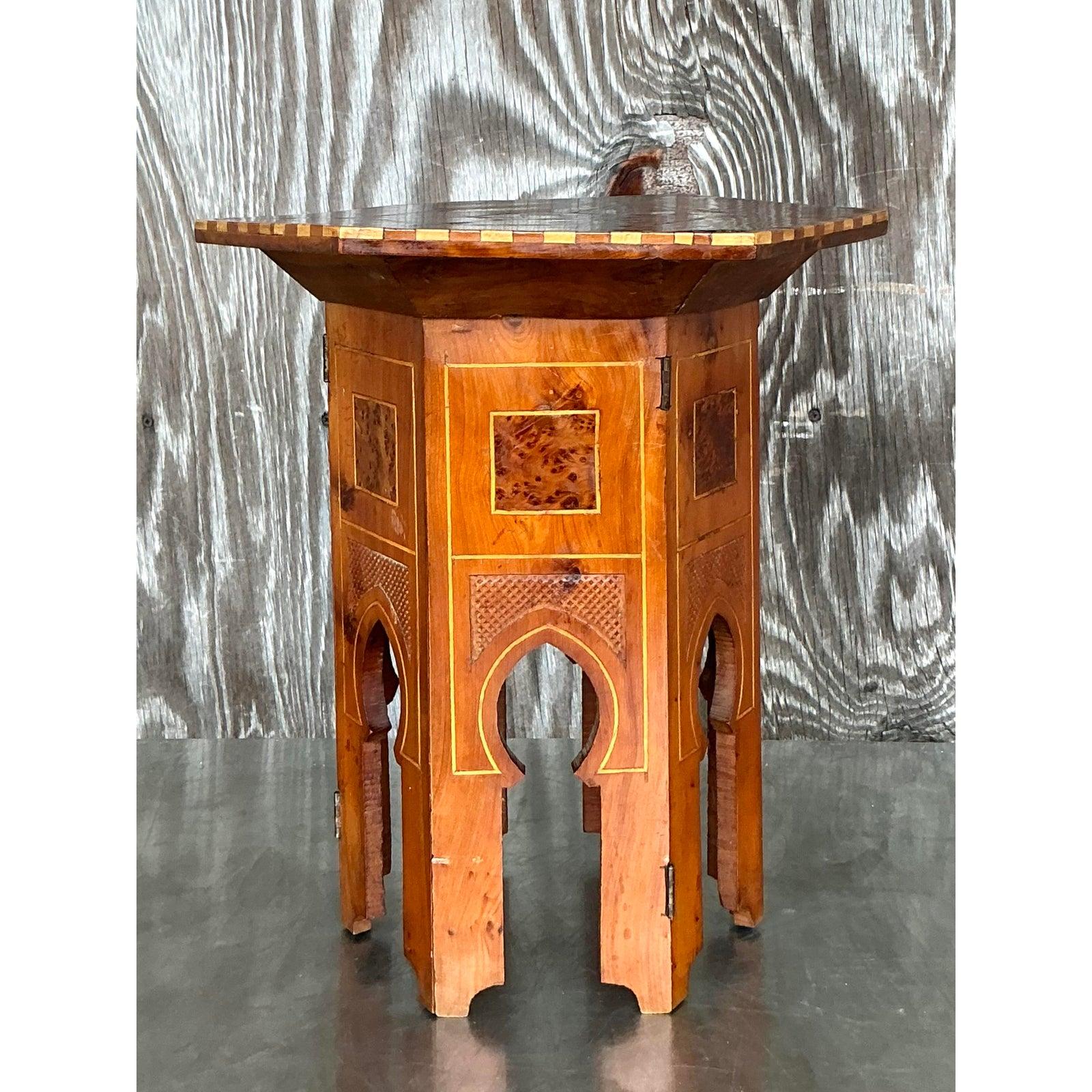 Infusez un charme mondial à votre intérieur avec cette table à boissons vintage unique, qui présente de magnifiques incrustations boho. Le plateau octogonal présente des dessins géométriques complexes et des motifs délicats, probablement réalisés à