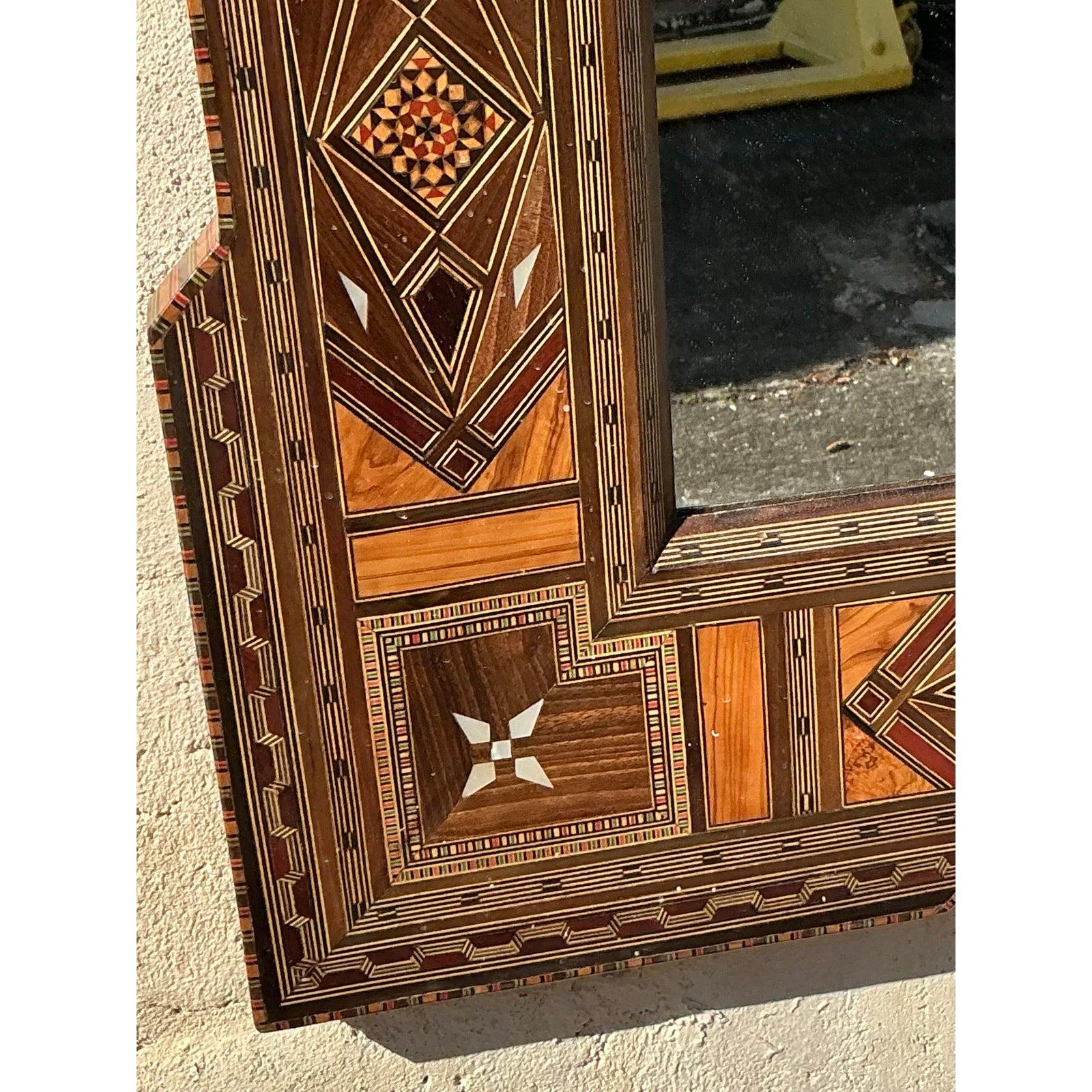 Ce miroir vintage exquis à incrustation boho est un témoignage frappant de l'artisanat magistral et de l'art complexe. La Nature présente des motifs géométriques et floraux méticuleusement incrustés à la main, mettant en valeur un mélange harmonieux