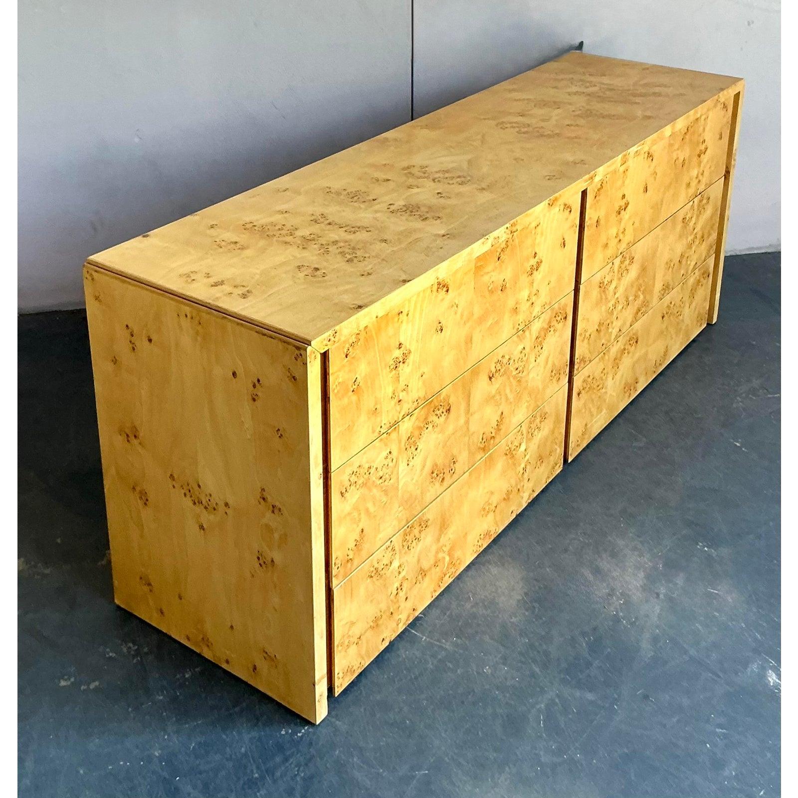 Embrace the pinnacle of 1970s glamour with this exquisite vintage burl wood dresser by Intrex. A masterclass in minimalist design, this piece allows the breathtaking beauty of the book-matched olive ash burl veneer to take center stage. The clean,