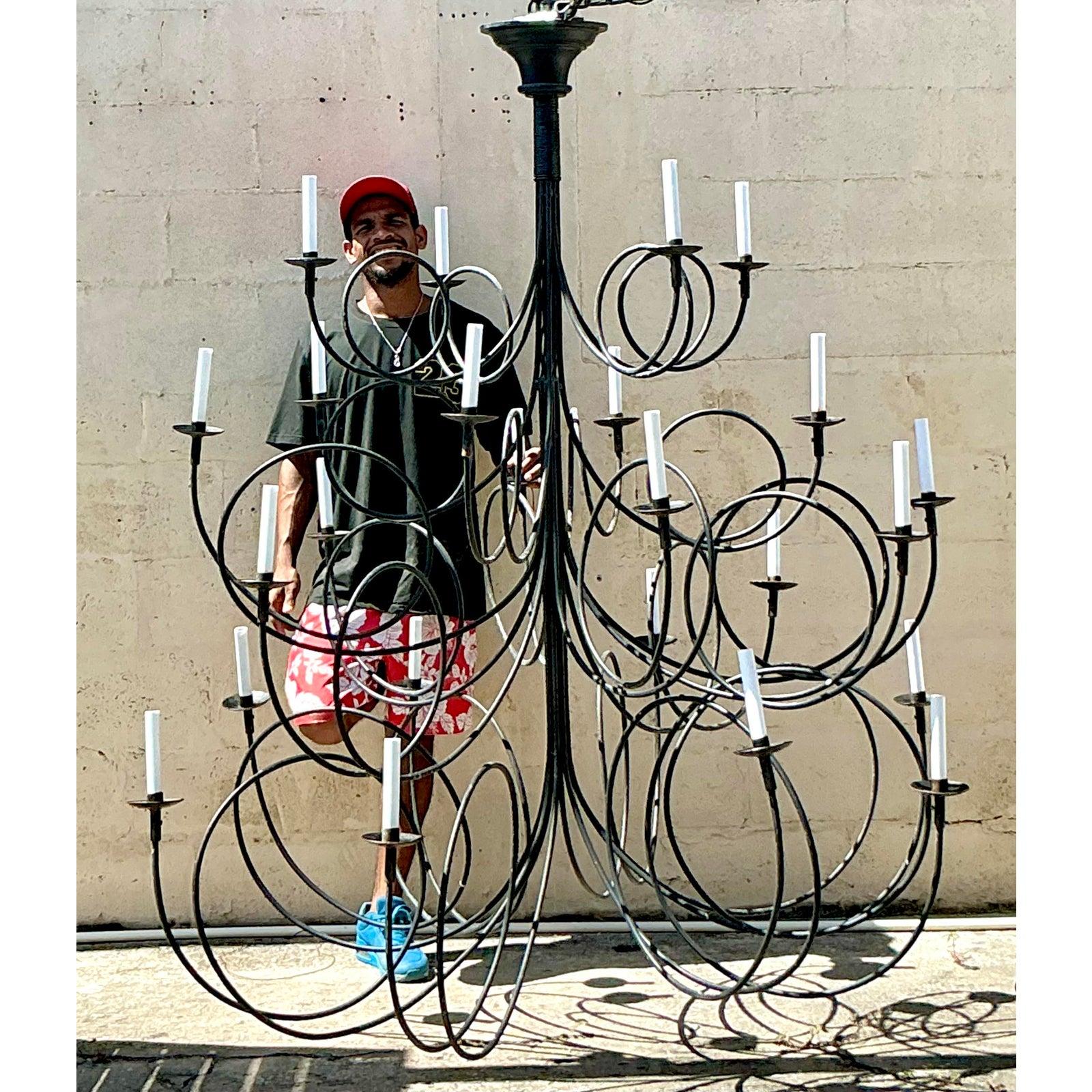 Make an unforgettable statement with this magnificent Vintage Boho Monumental Loop Chandelier, a true testament to bold mid-century design and artistic vision. Crafted from robust metal with an elegant dark finish, this extraordinary piece features