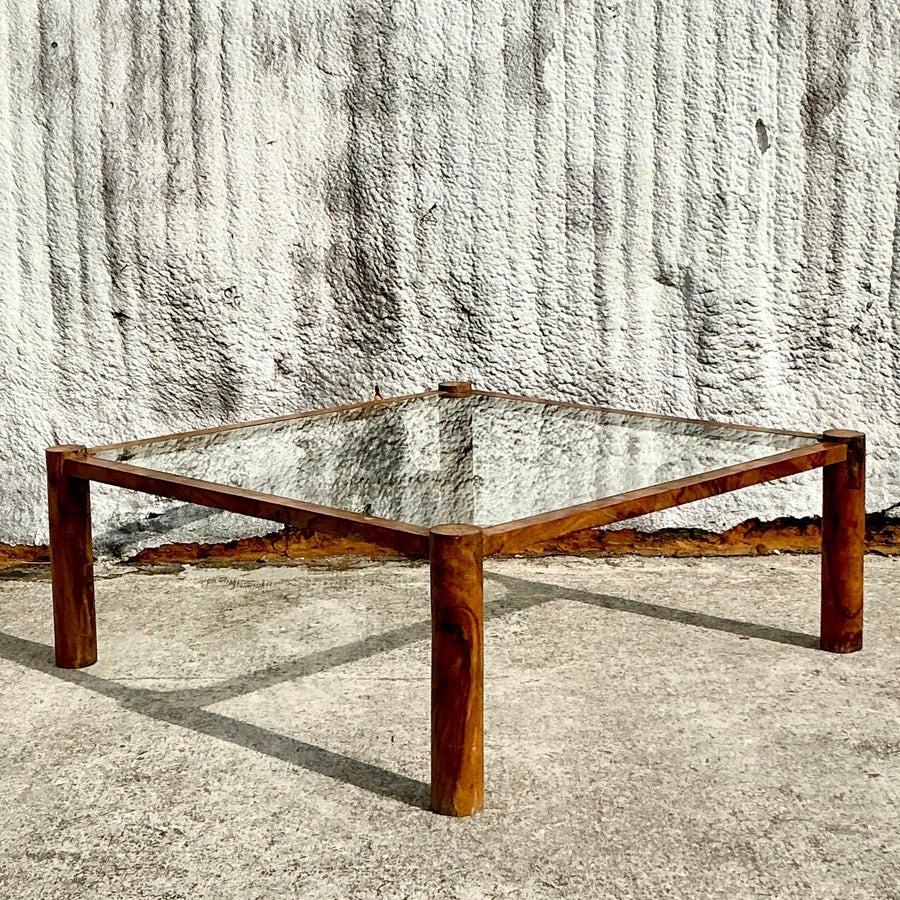 Aggiungi un tocco di raffinatezza boho italiana al tuo spazio con questo tavolino vintage in radica di ulivo. Questo tavolo, che mette in mostra le straordinarie venature naturali del legno d'ulivo, presenta un design organico ed elegante che unisce