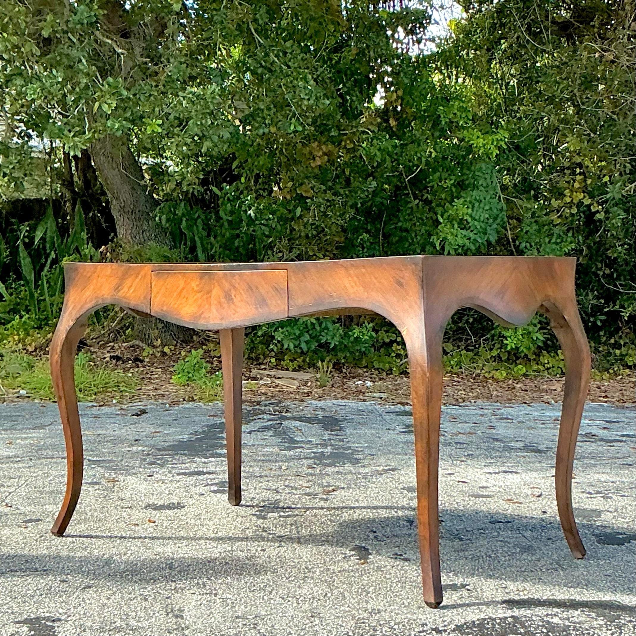 Questo scrittoio italiano in radica fonde il fascino Boho con l'eleganza della metà del secolo scorso. Grazie alle ricche venature del legno di radica e alle linee scolpite, è perfetto per aggiungere carattere a qualsiasi spazio. Ideale come
