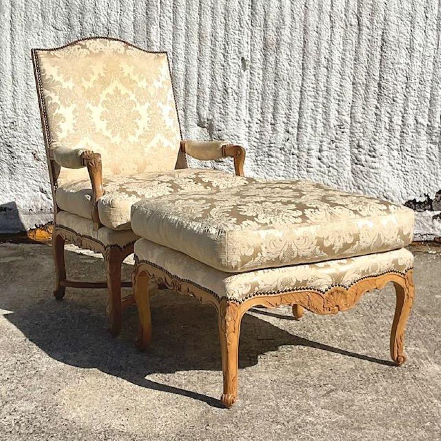 A fabulous vintage Boho chair and ottoman. A chic high back style with a gorgeous neutral Fleur de Lys jacquard upholstery with heavy down cushions. Beautiful hand carved frame with beautiful wood grain detail. Acquired from a Palm Beach