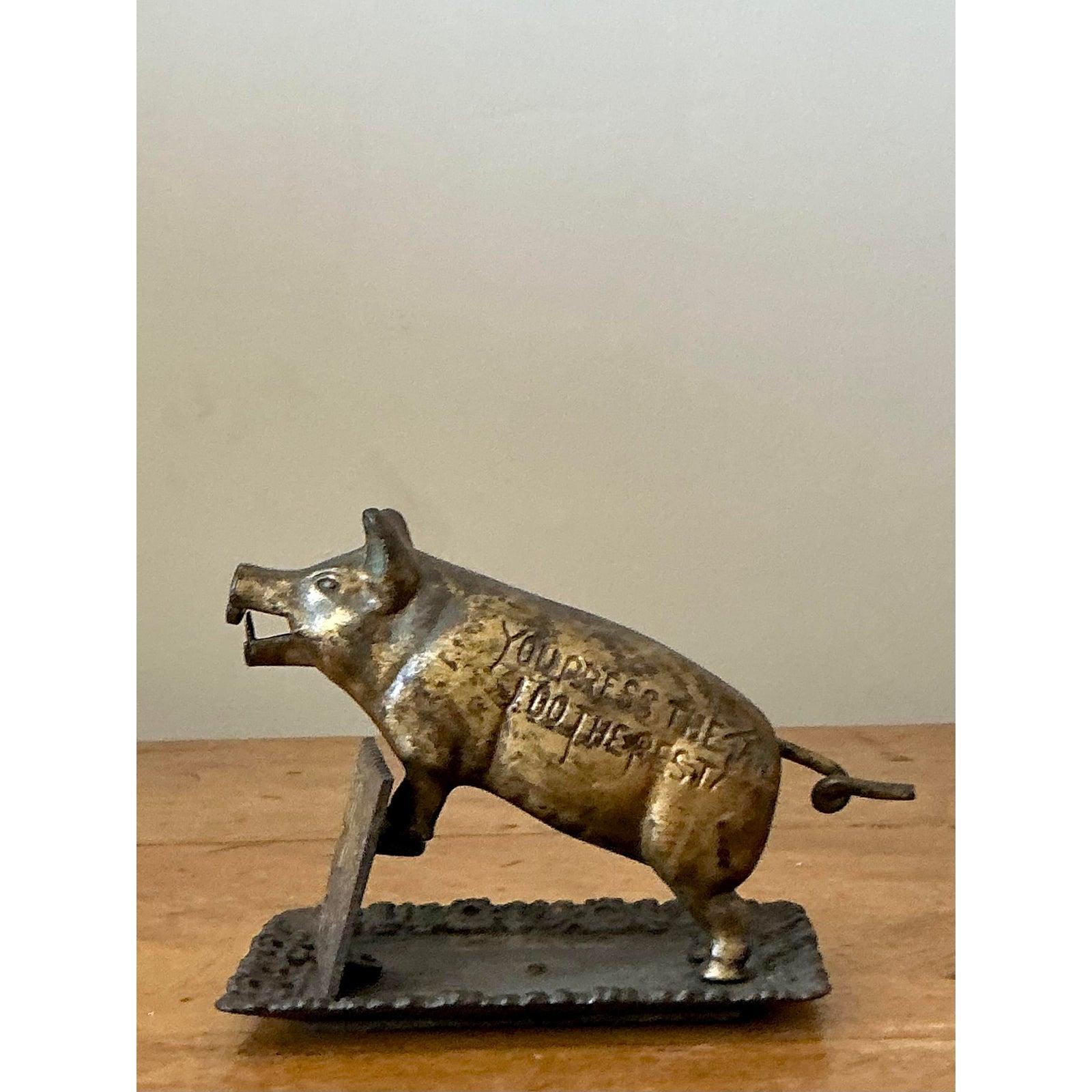 Questo maiale in ottone fuso, delizioso e funzionale, è sia un tagliasigari meccanico che un affascinante salvadanaio. Realizzato in metallo pesante e patinato, questo pezzo emana un carattere antico e presenta la spiritosa iscrizione incisa: 