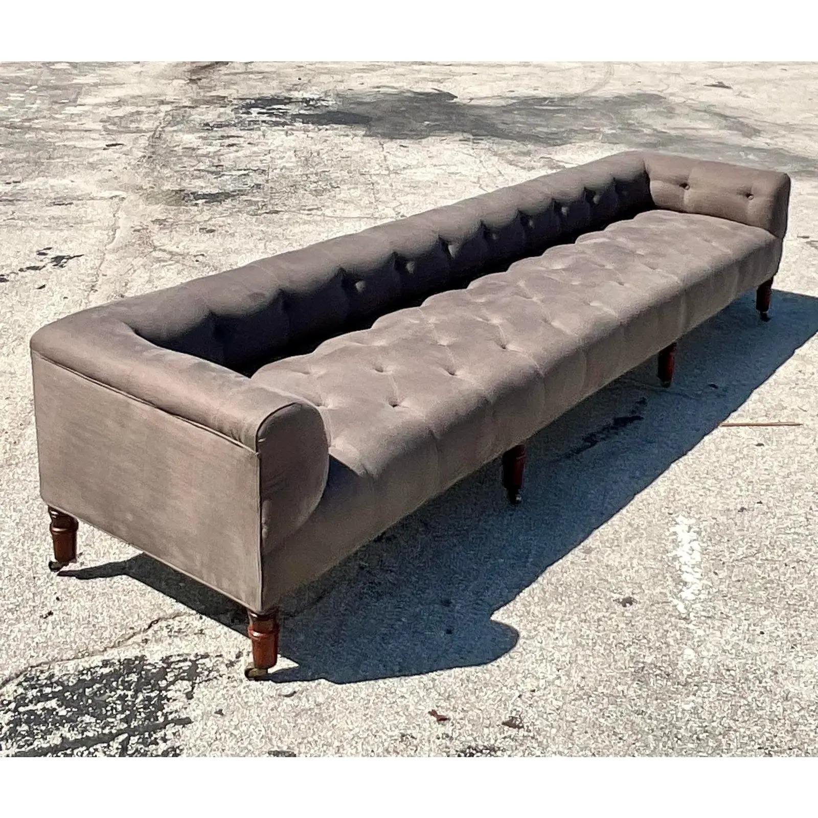 Fantastic vintage Boho tufted sofa. Made by the iconic John Derian company. Beautiful Belgian linen with a chic 9ft frame. Low profile with turned wood legs on casters. Acquired from a Palm Beach estate. Measure: 9ft.