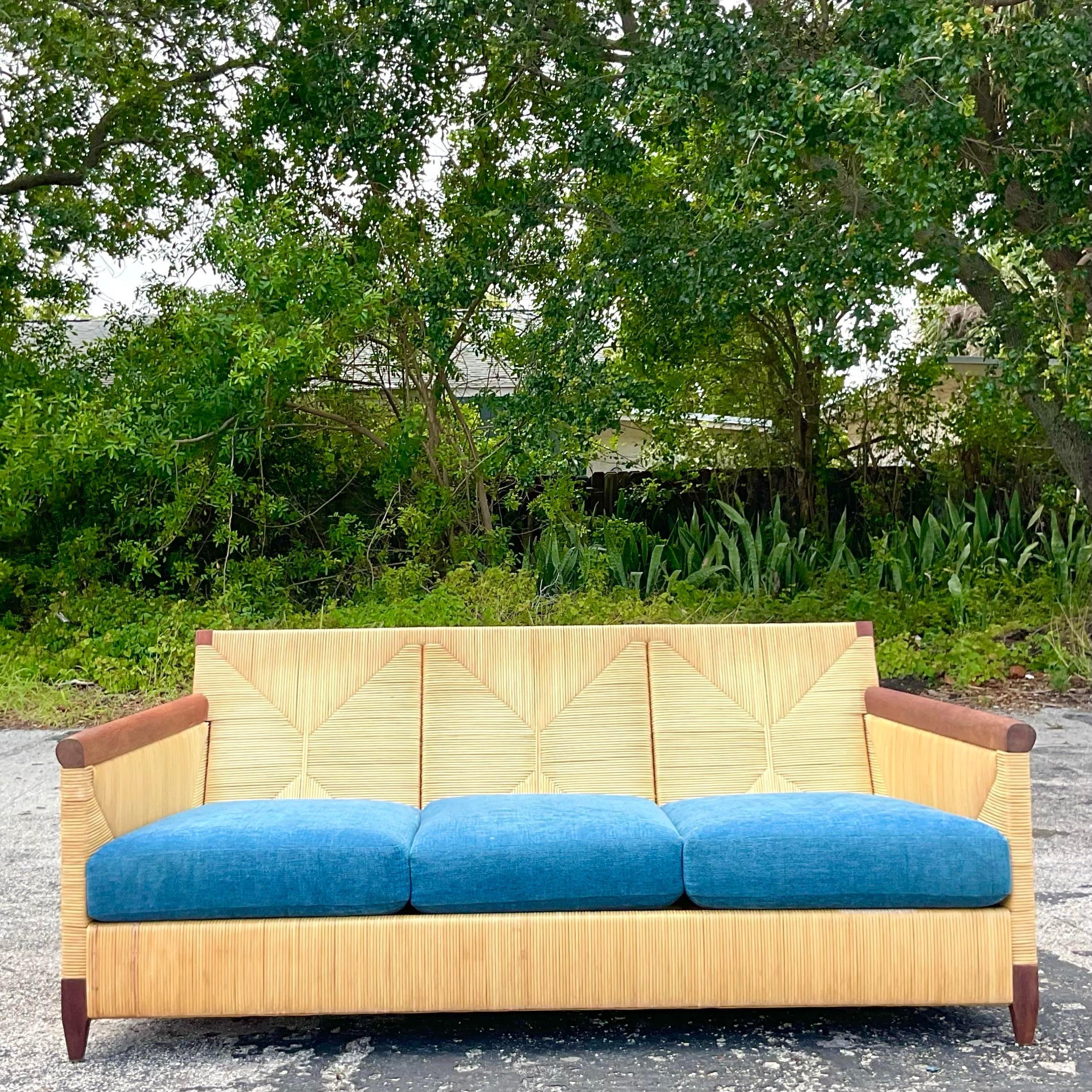 Verschönern Sie Ihren Wohnbereich mit dem Vintage Boho John Hutton for Donghia Block Island Rattan Sofa. Dieses in den USA gefertigte Kultobjekt verbindet Bohème-Flair mit amerikanischer Handwerkskunst und bietet eine zeitlose Mischung aus Komfort