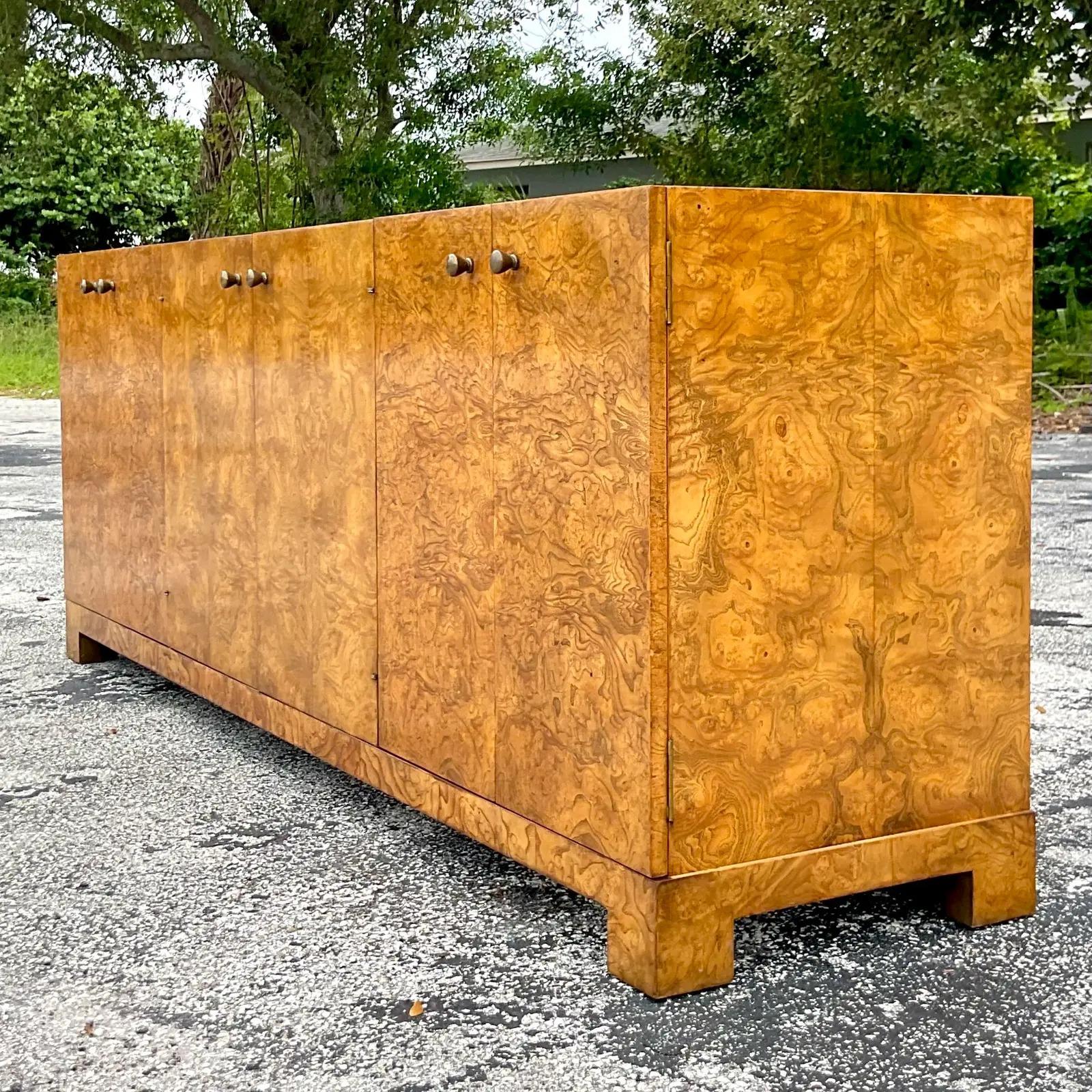 A spectacular vintage MCM credenza. Monumental in size and drama. Made by the iconic John Widdicomb and tagged on the inside. Magnificent Burl wood cabinet with lots of great storage below. Acquired from a palm beach estate.