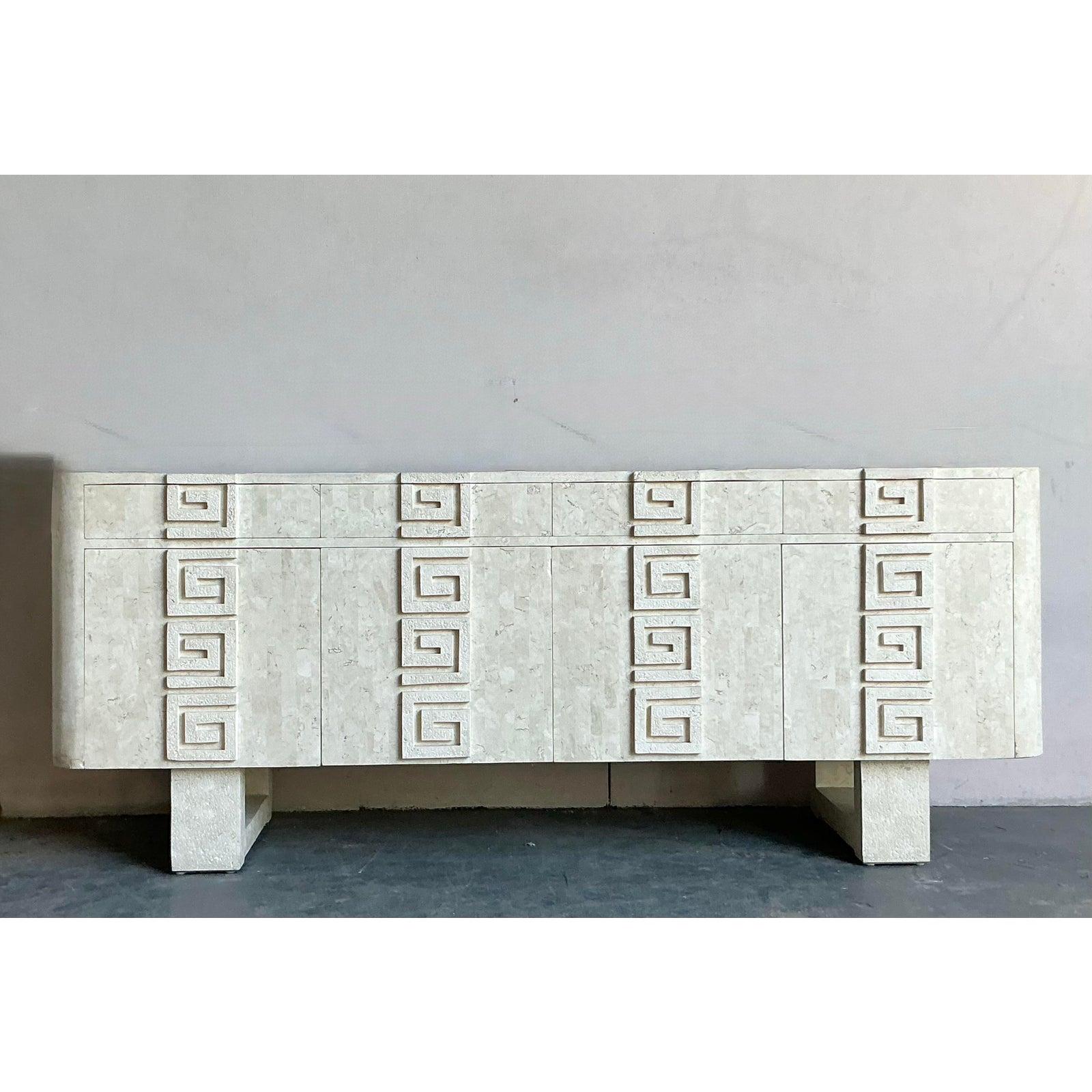 This exceptional credenza is a striking example of the monumental, architectural design popular in the Postmodern and Hollywood Regency eras. The structure boasts a monolithic presence, entirely surfaced in a textured, light-colored tessellated