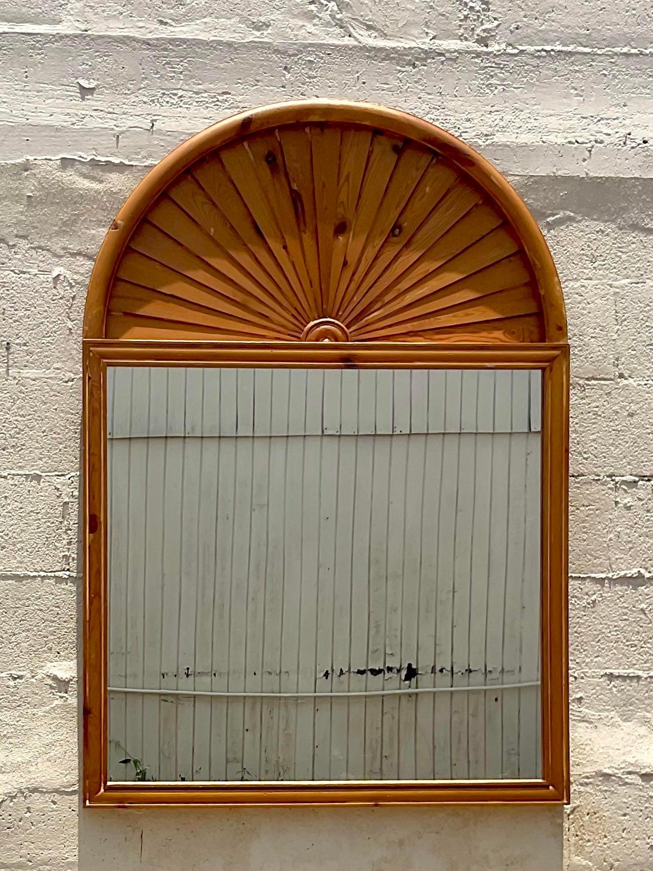 A fabulous vintage Boho wall mirror. A chic fan top design constructed in a knotty pine wood. Acquired from a Palm Beach estate. 