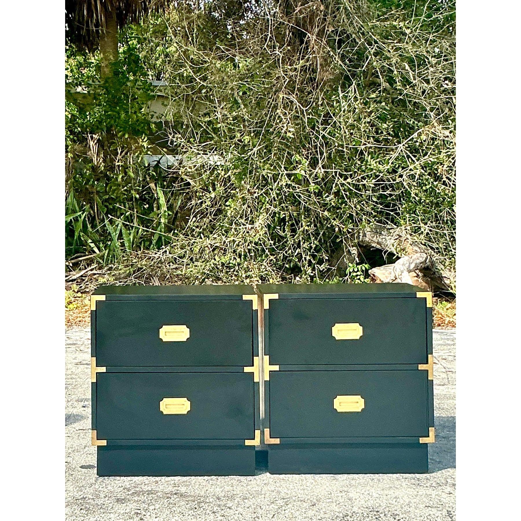 Elevate your bedroom or living space with this stunning pair of vintage lacquered campaign nightstands. Featuring a sleek black lacquer finish accented with bold brass hardware and corner brackets, these pieces exude timeless sophistication with a