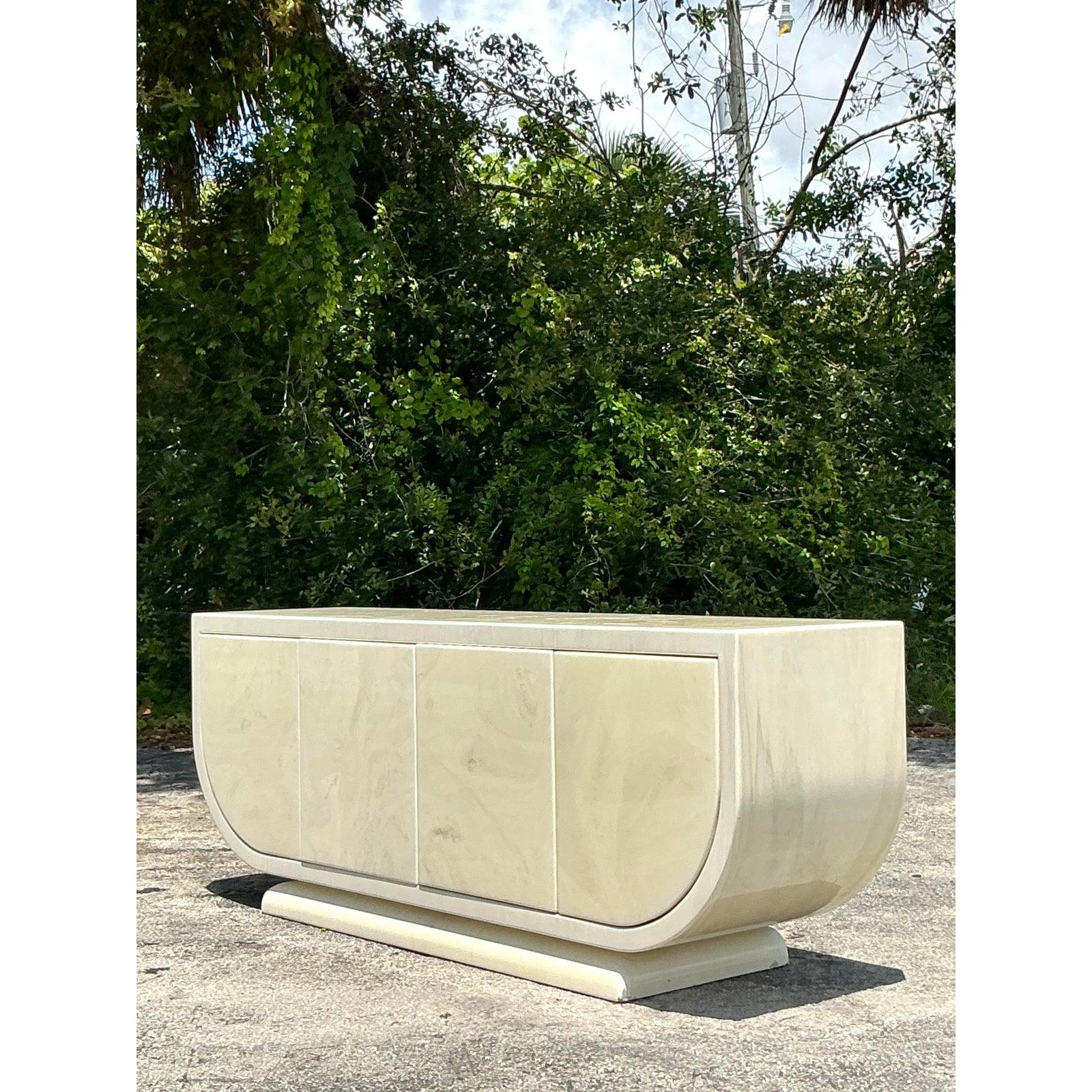 Embrace the glamorous and sculptural forms of the Postmodern era with this magnificent lacquered credenza. A true statement piece, its defining feature is the dramatic waterfall silhouette, where the sides curve seamlessly to form a continuous,