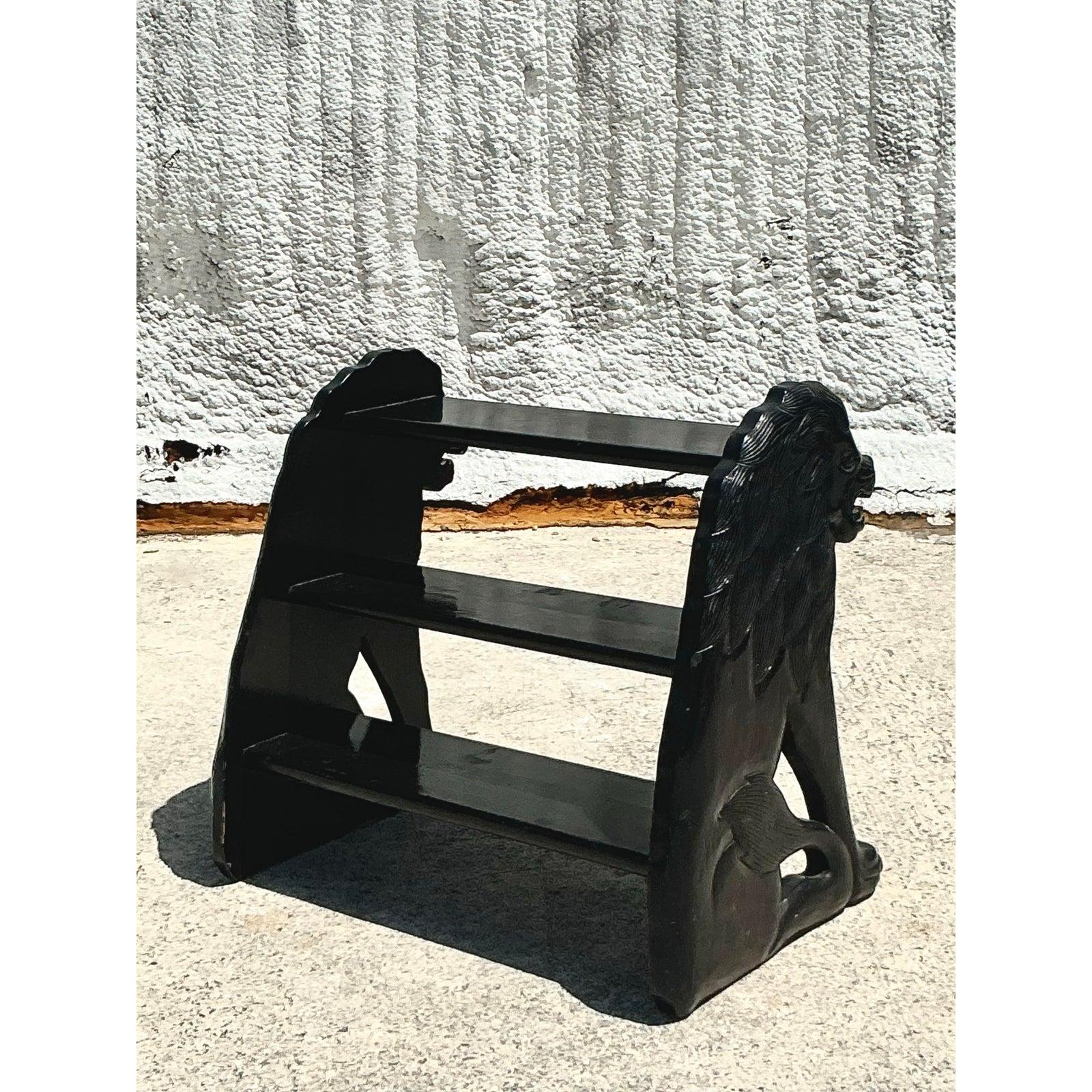 Faites une déclaration audacieuse et inattendue avec ce tabouret marchepied de bibliothèque vintage boho laqué en forme de lion. Cette pièce unique présente des lions sculptés à la main de chaque côté, avec une finition en laque noire élégante pour