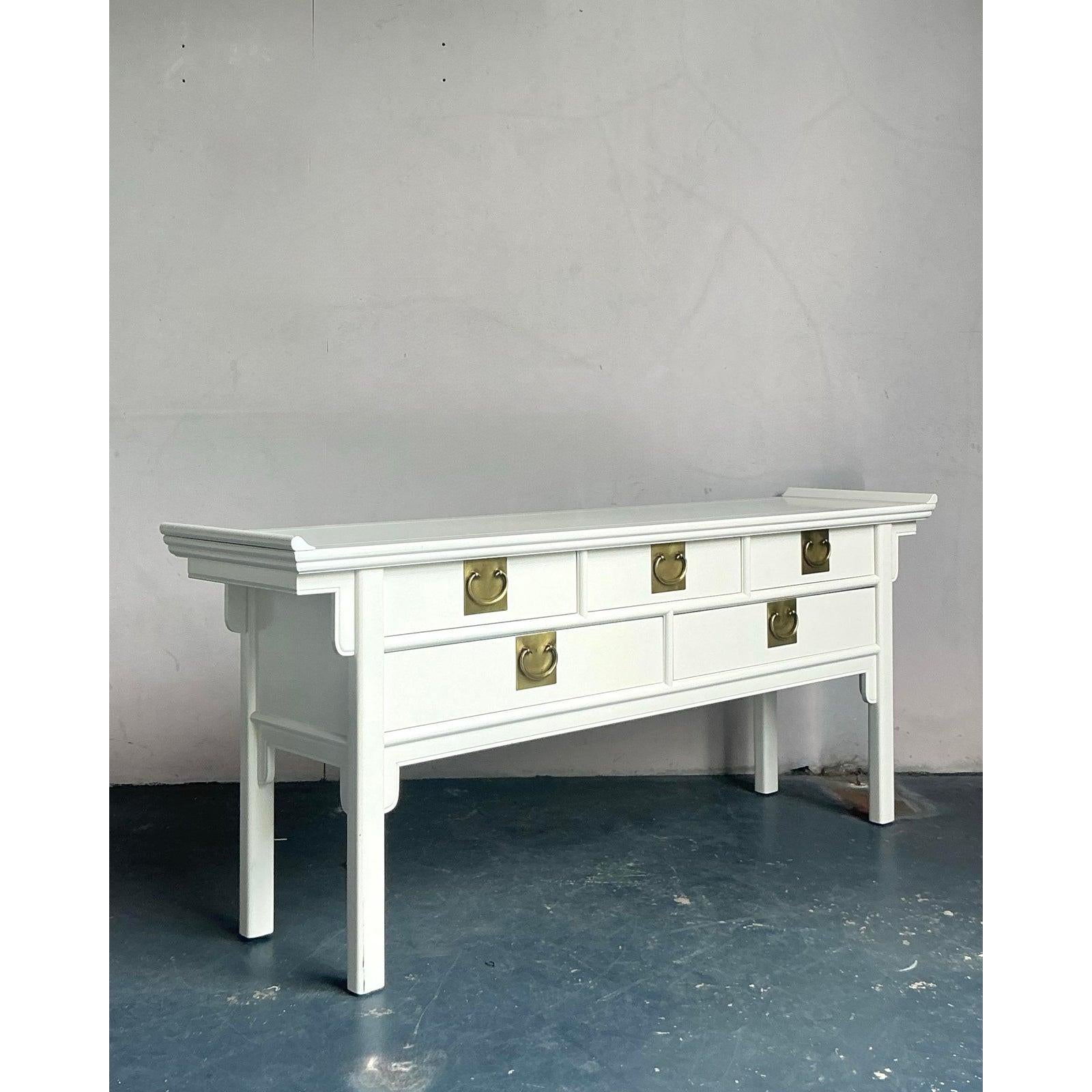 Presenting a stunning vintage console table that beautifully marries Boho Chic sensibilities with the elegant lines of Hollywood Regency and Asian-inspired design. This exquisite piece features a lustrous lacquered finish, showcasing a graceful