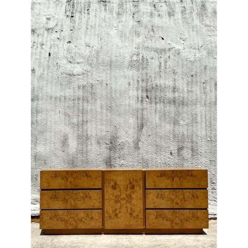 Eleva tu interior con esta excepcional credenza Vintage Boho Lane Burl, testimonio del exquisito diseño de mediados de siglo y de la maestría artesanal. La llamativa chapa de madera burlada, famosa por sus veteados únicos e intrincados, crea un