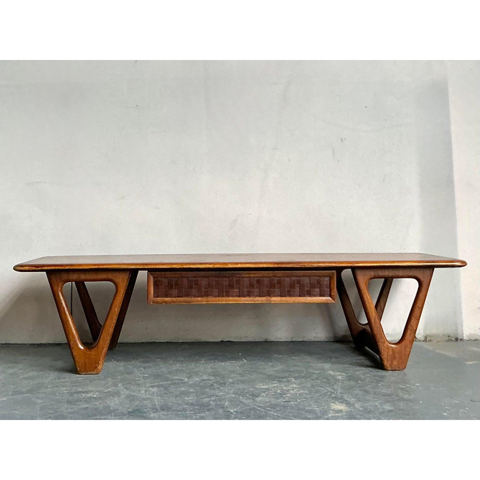 An authenticated piece from the highly sought-after “Perception” series by Lane Furniture, this coffee table is a hallmark of American Mid-Century Modern design. Crafted from warm walnut or teak-toned wood, the table features a long, floating