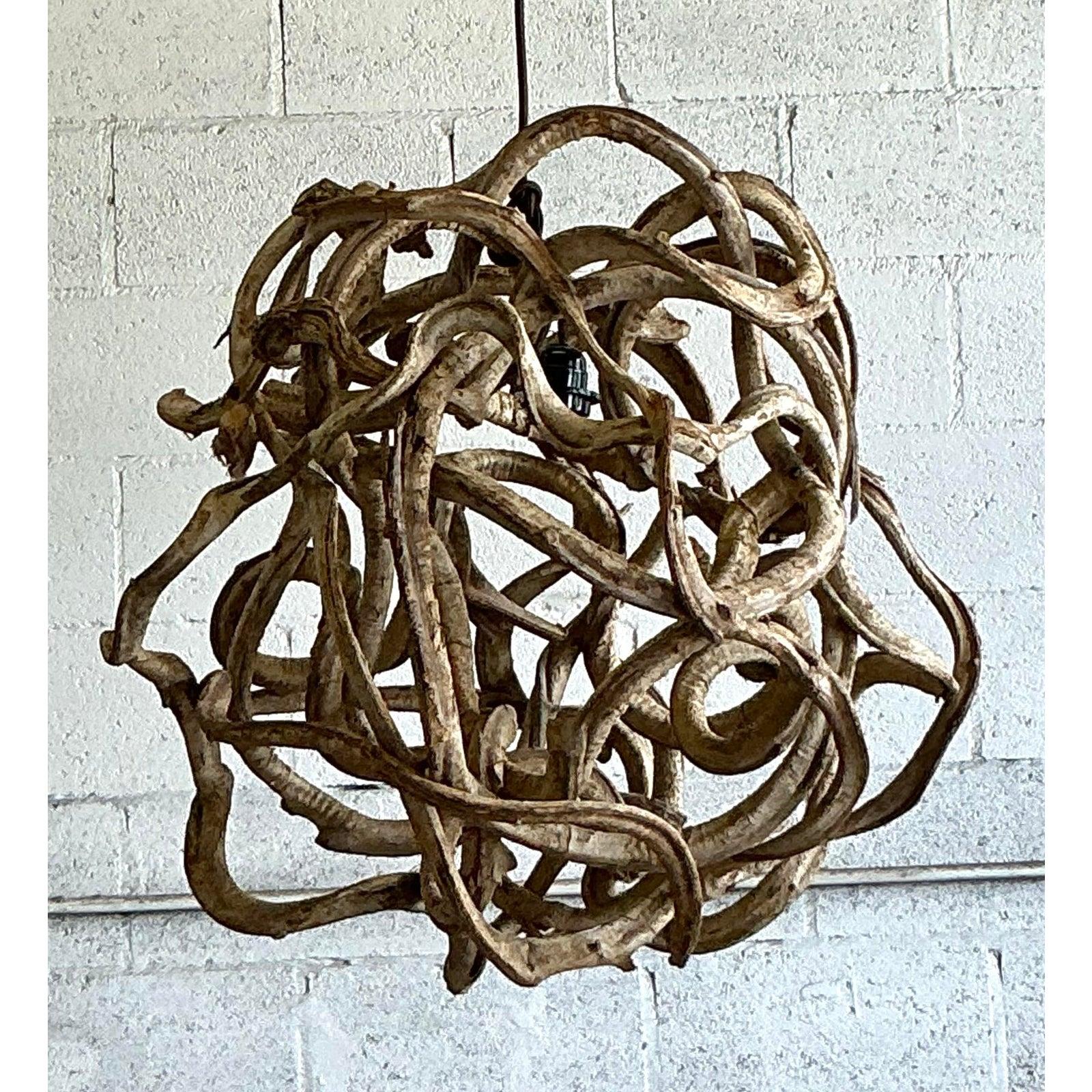 Immerse your space in the raw, organic beauty of this truly sculptural vintage root ball chandelier. A testament to nature's artistry, this monumental fixture is meticulously formed from intricately intertwined natural roots or vines, creating a