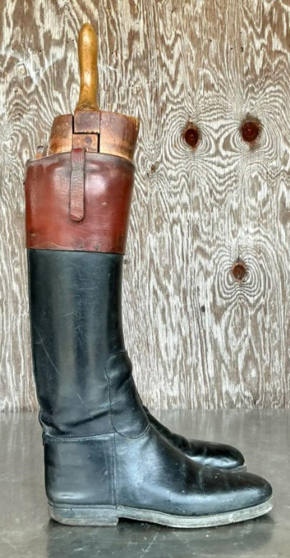 Questo paio di stivali da equitazione in pelle vintage, che unisce funzionalità e stile, è dotato di forme in legno splendidamente invecchiate. Realizzati in classica pelle nera con finiture marroni e suole patinate, questi stivali hanno un