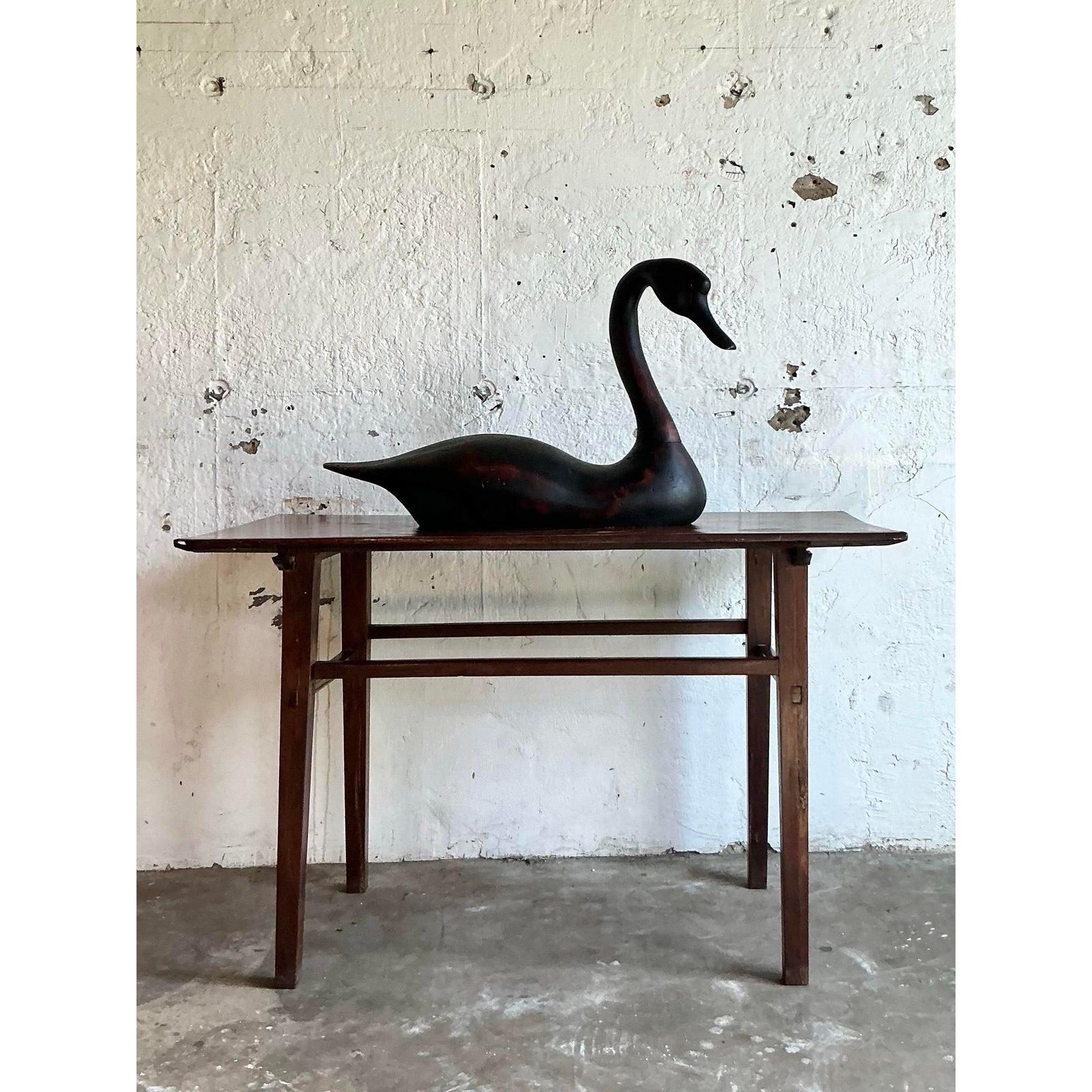 Cattura la serena eleganza della natura con questa splendida scultura di cigno a grandezza naturale. Sapientemente intagliato a mano in legno massiccio e rifinito in una profonda tonalità ebanizzata, questo pezzo incarna un'estetica moderna