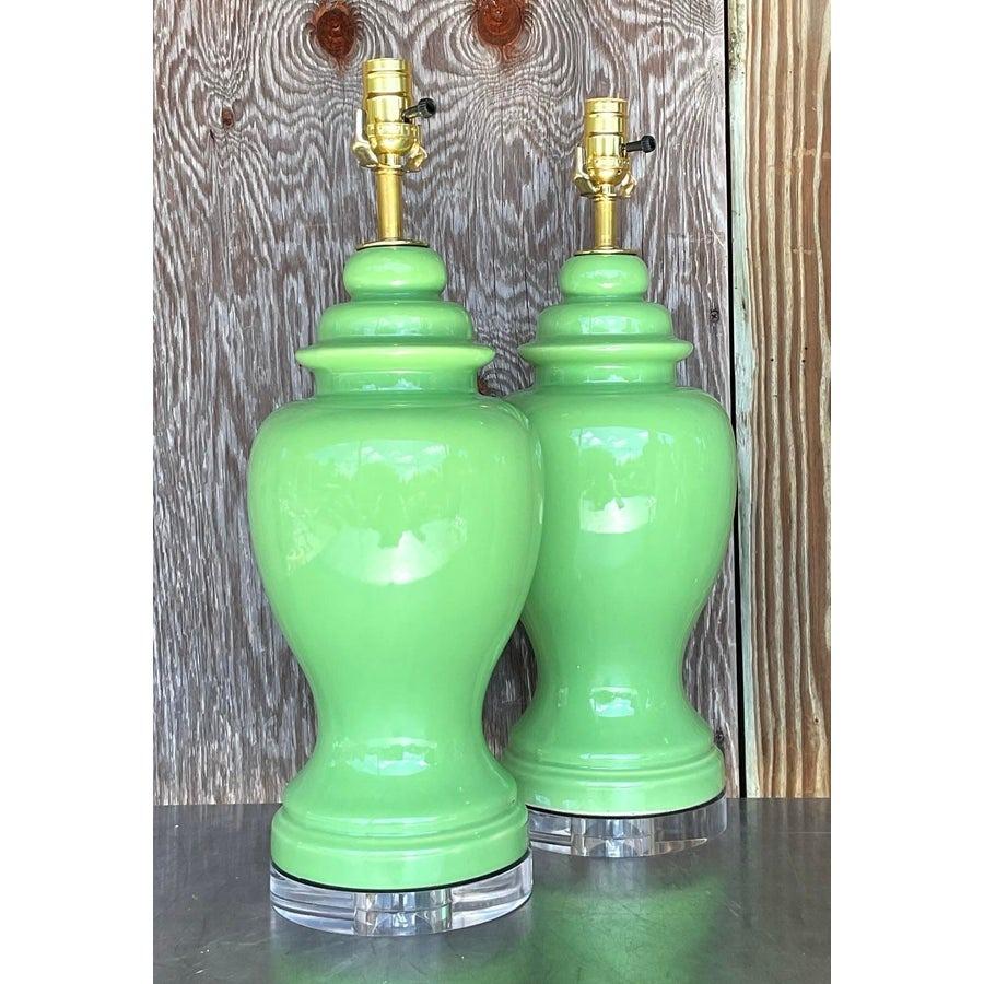 Add a vibrant touch of mid-century elegance to your interior with this stunning pair of Vintage Boho Lime Green Ceramic Ginger Jar Lamps. These striking lamps feature a glossy lime green finish on classic ginger jar bases, beautifully complemented