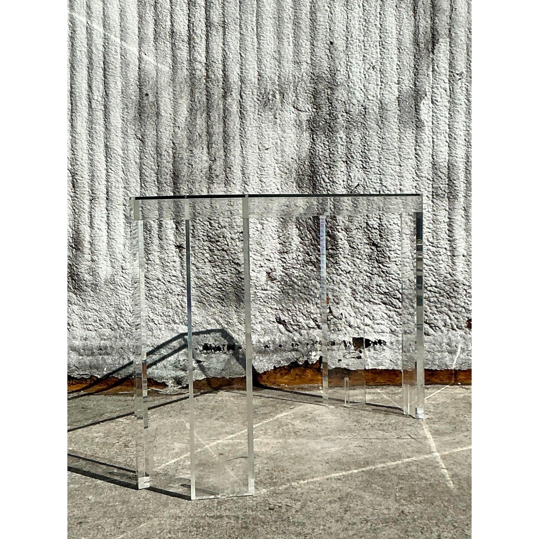 Add a touch of sleek sophistication to your space with this vintage boho lucite console table. Crafted from crystal-clear lucite, this piece offers a minimalist yet eye-catching design that seamlessly integrates with modern, bohemian, or eclectic