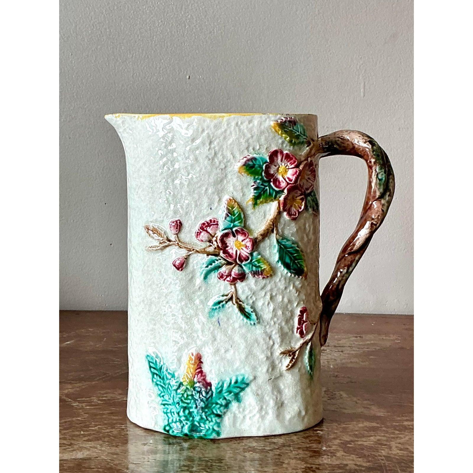 Esempio accattivante di arte ceramica tardo-vittoriana, questa brocca antica in maiolica è ricca di fascino naturalistico. Il corpo della brocca è magistralmente modellato con una texture 
