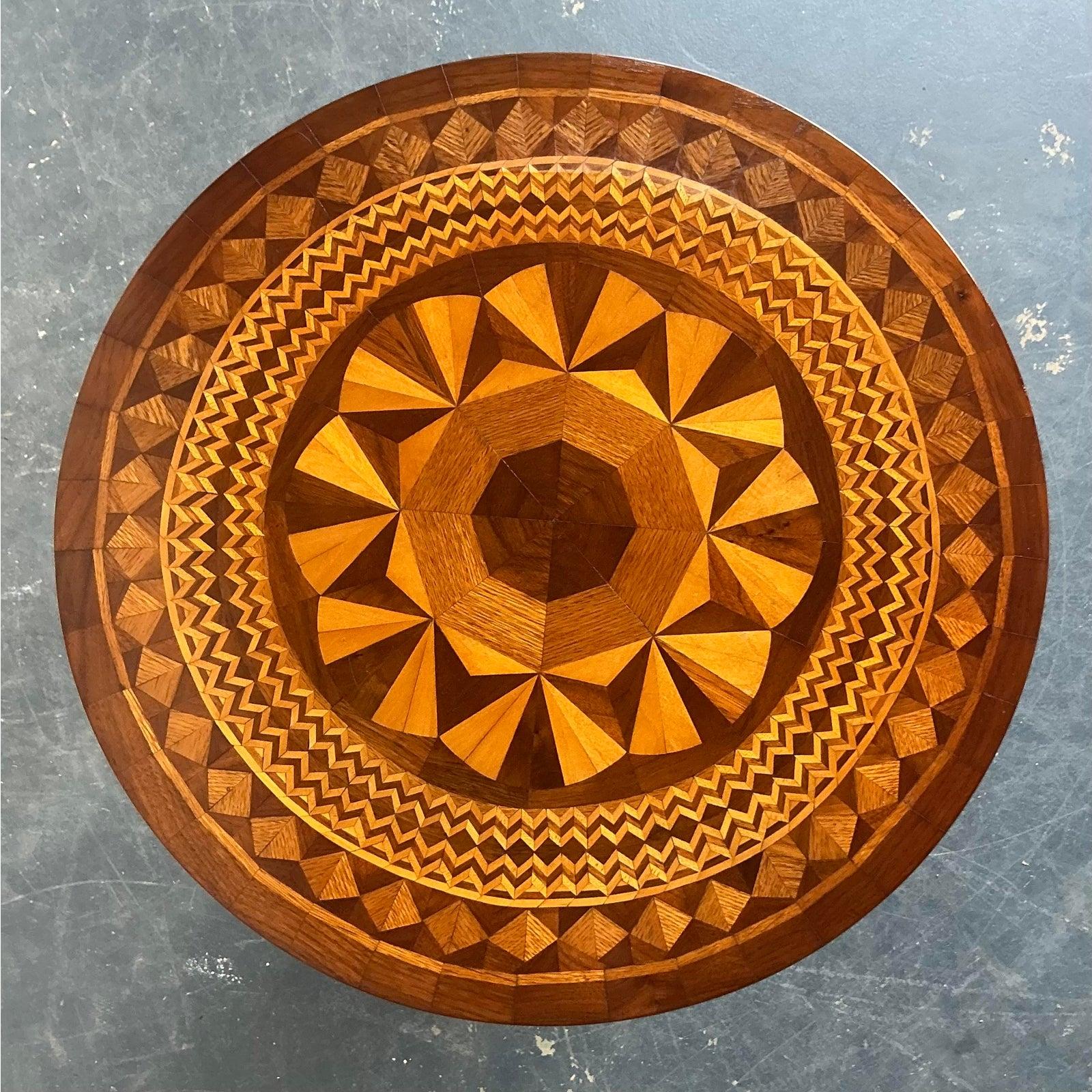 Scopri la bellezza intricata di questo tavolino vintage, una vera e propria testimonianza dell'arte dell'intarsio. Questo pezzo accattivante presenta una squisita lavorazione a intarsio del legno, che forma ipnotici motivi geometrici sul piano