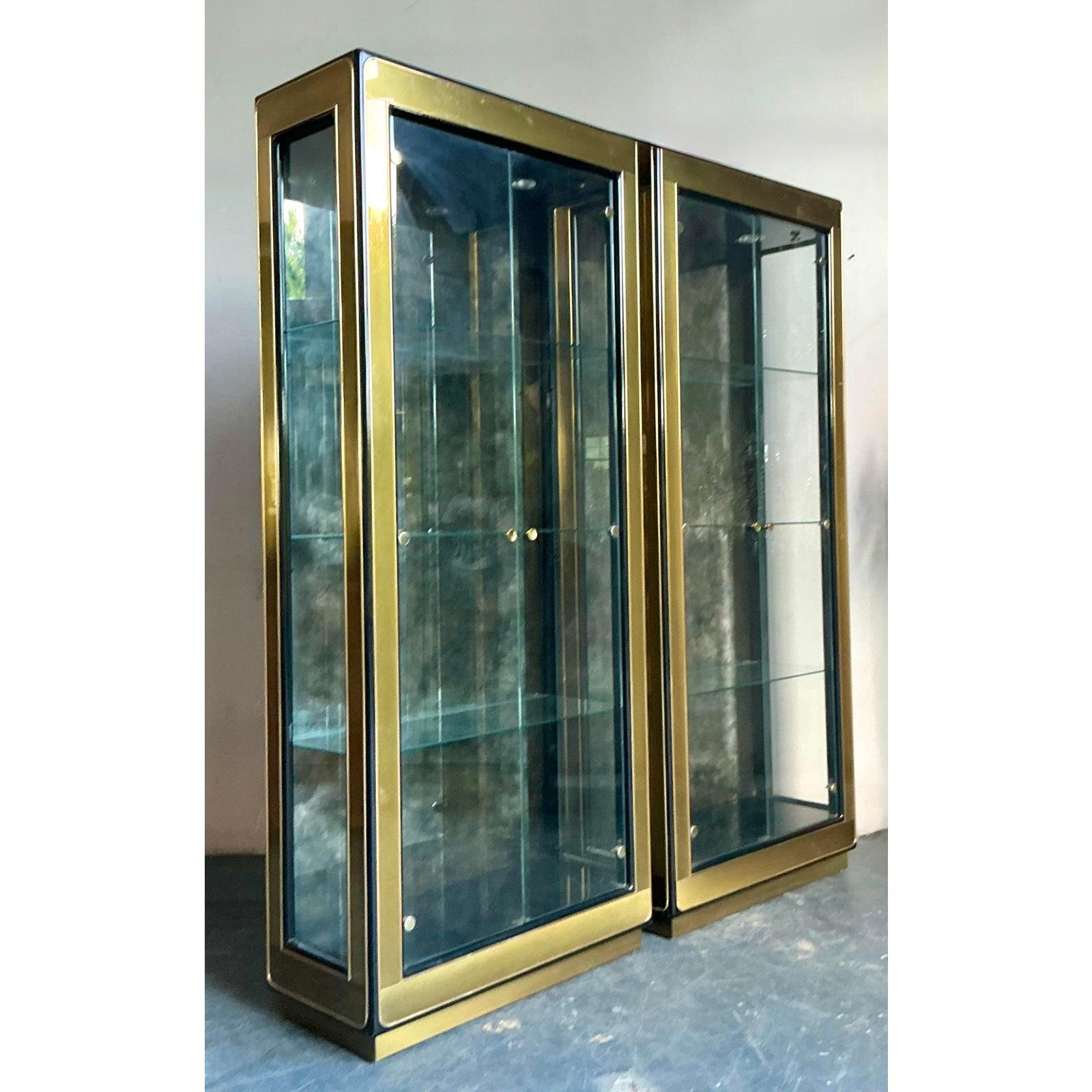 Cet imposant cabinet de curiosités vintage incarne le design moderne haut de gamme, caractérisé par sa silhouette rectiligne et sévère et sa luxueuse finition en laiton. L'armoire se compose d'un cadre robuste en laiton poli ou en métal plaqué