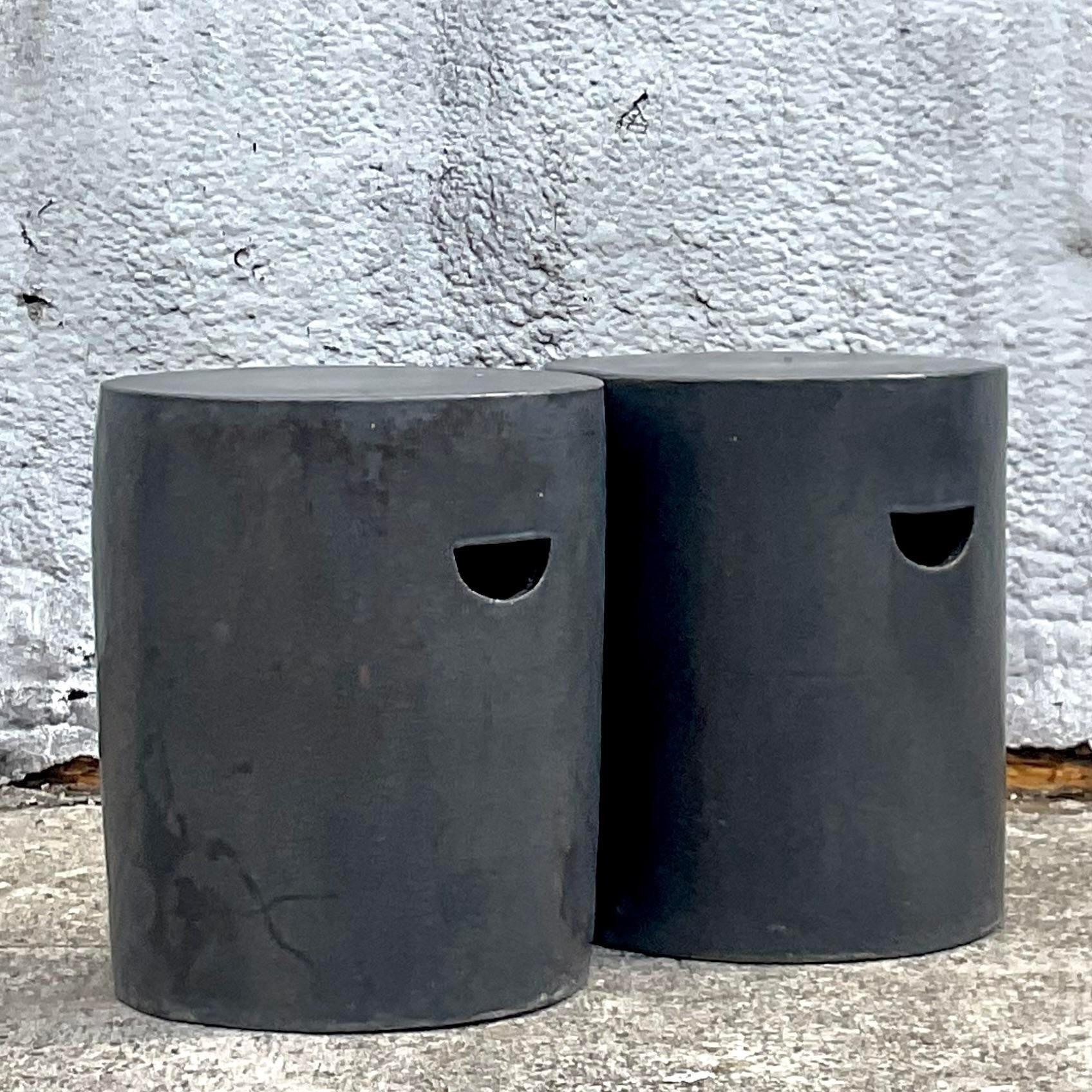 A fabulous pair of vintage Boho low stools. A chic matte glazed ceramic in a clean and modern shape. A fabulous dark grey color is a perfect neutral for so many spaces. Acquired from a Palm Beach estate.