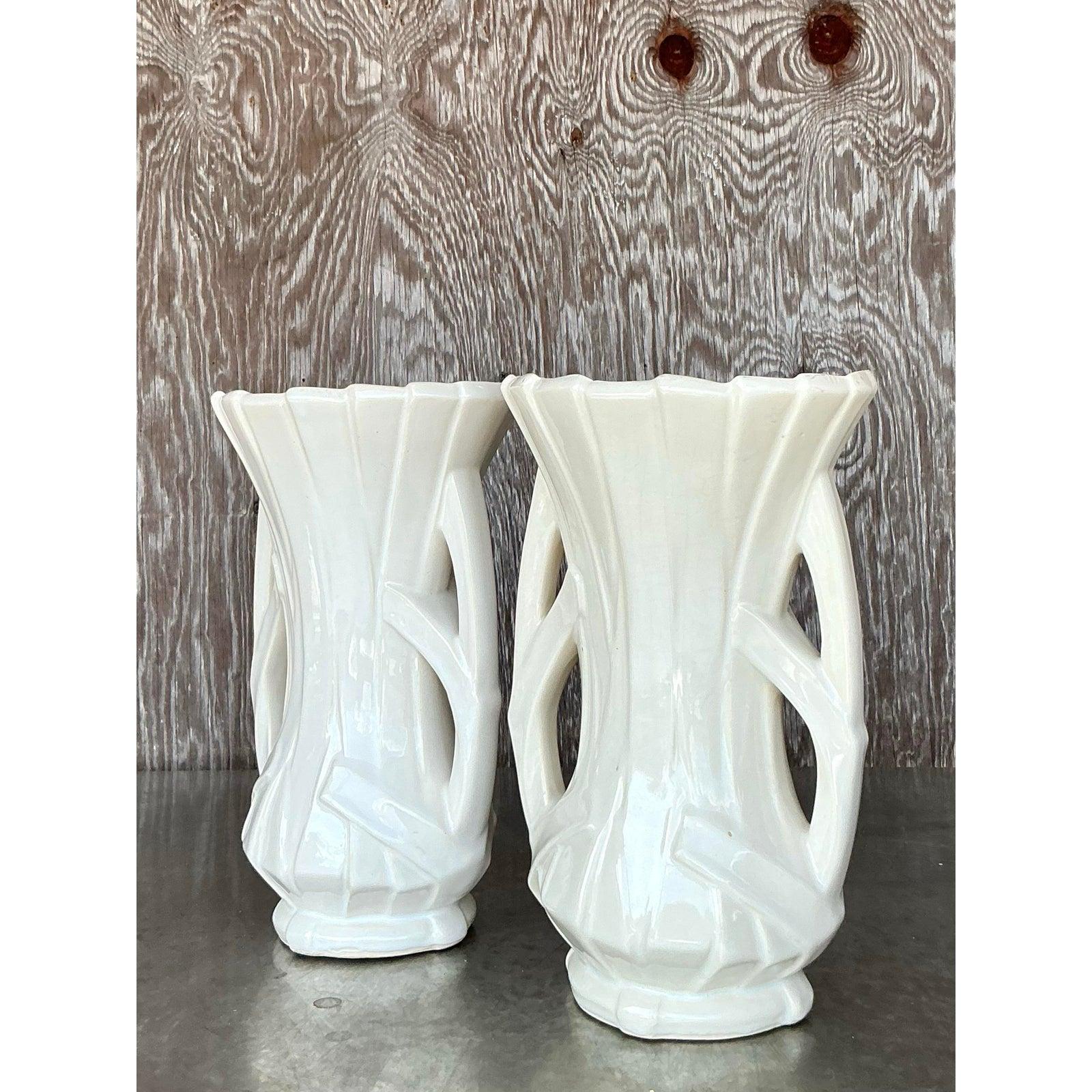 Aggiungi un tocco di eleganza vintage al tuo spazio con questa splendida coppia di vasi a nastro McCoy. Realizzati con intricati dettagli traforati e una silhouette scultorea, questi vasi emanano un fascino di ispirazione Art Déco con un tocco