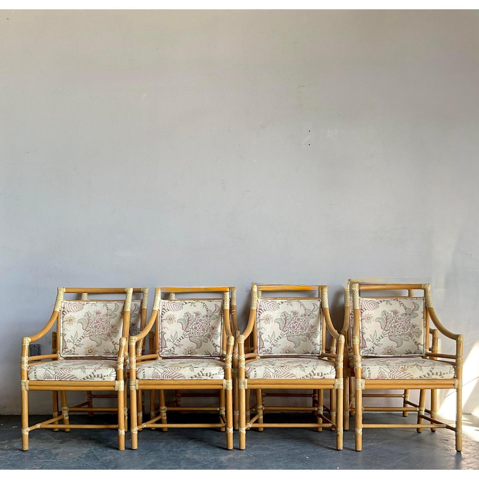 This elegant pair of vintage armchairs perfectly captures the light sophistication of the Hollywood Regency and Coastal aesthetics. The frames are constructed from natural rattan, featuring gently curving backs and elegantly flared arms wrapped