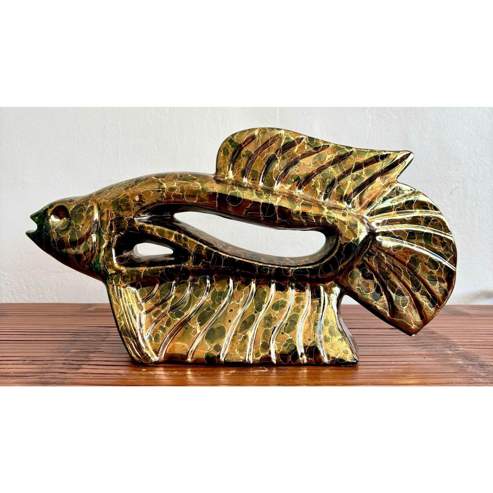 Questa scultura di pesce astratto è caratterizzata da uno smalto iridescente ad alta lucentezza con crepe intricate e uno spettro di bronzo profondo, verde, oro e accenni di blu. Le sezioni cave all'interno del corpo creano un gioco dinamico di luci