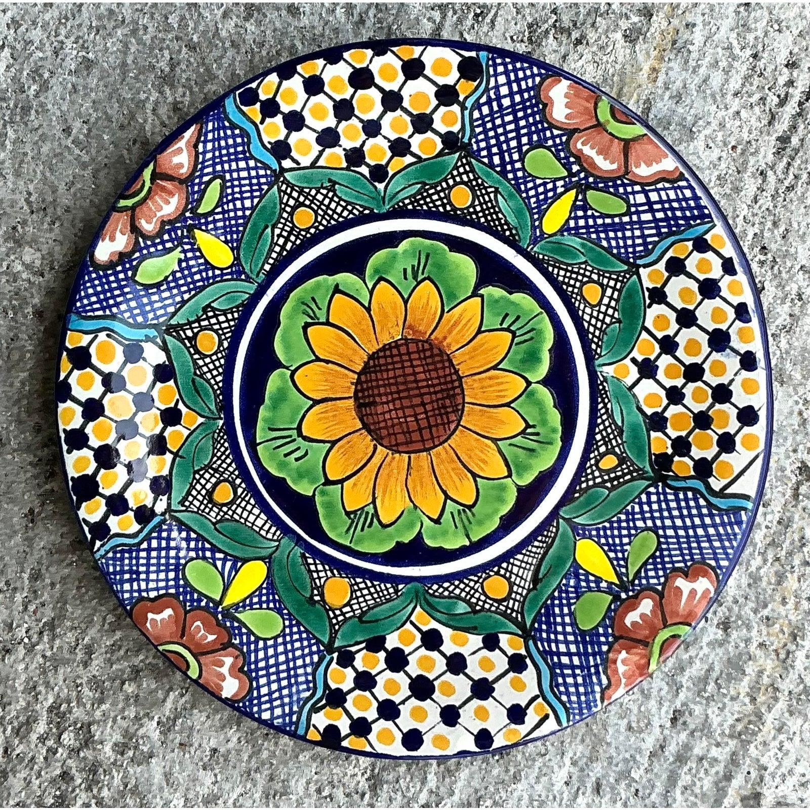 Celebrate vibrant craftsmanship with this Vintage Boho Mexican Hand Painted Ceramic Plate, featuring a radiant sunflower at its center surrounded by intricate geometric and floral motifs. Handmade in the traditional Talavera style, this lead-free
