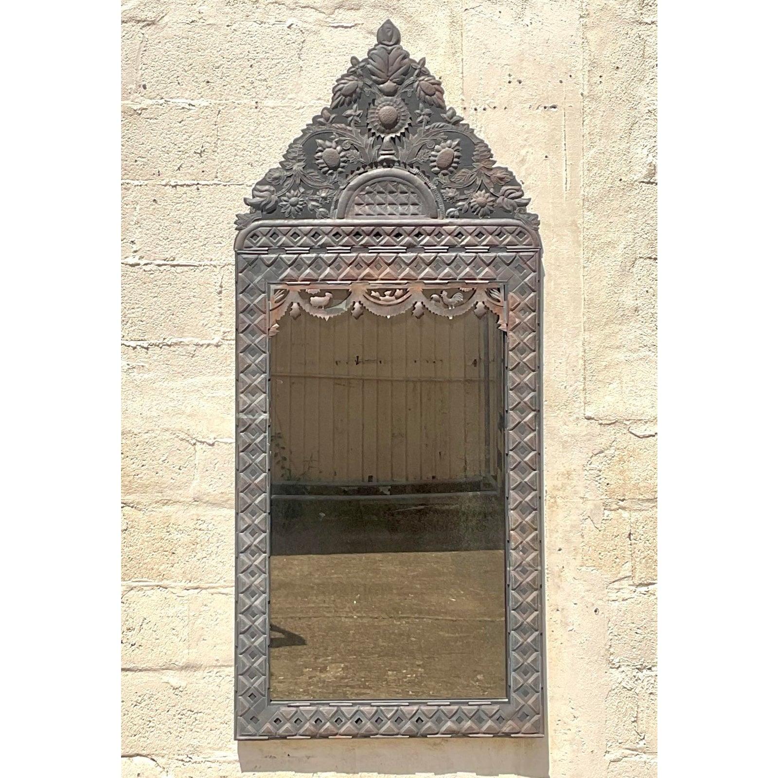 Infondi nel tuo spazio un ricco fascino culturale e una bellezza artigianale con questo straordinario specchio vintage messicano in metallo stampato. Realizzato con intricati motivi floreali e geometrici, questo specchio alto e stretto mostra