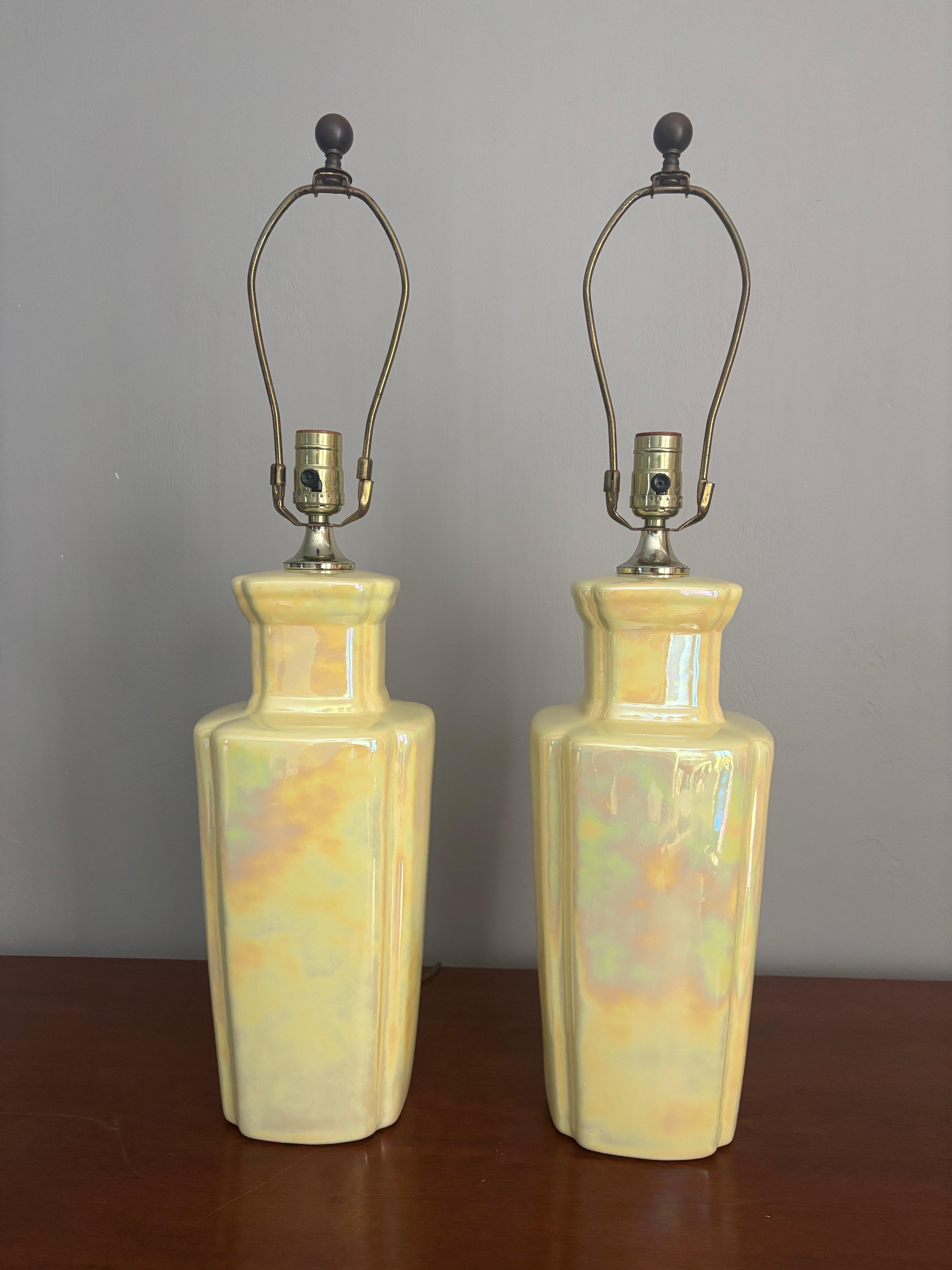Bellissima coppia di lampade in ceramica vintage. Un'epoca di metà secolo con un tocco di design mediterraneo nel profilo. Un bellissimo giallo pallido con uno smalto lustro che dà l'impressione di un effetto iridescente. 

Una tecnica di ceramica