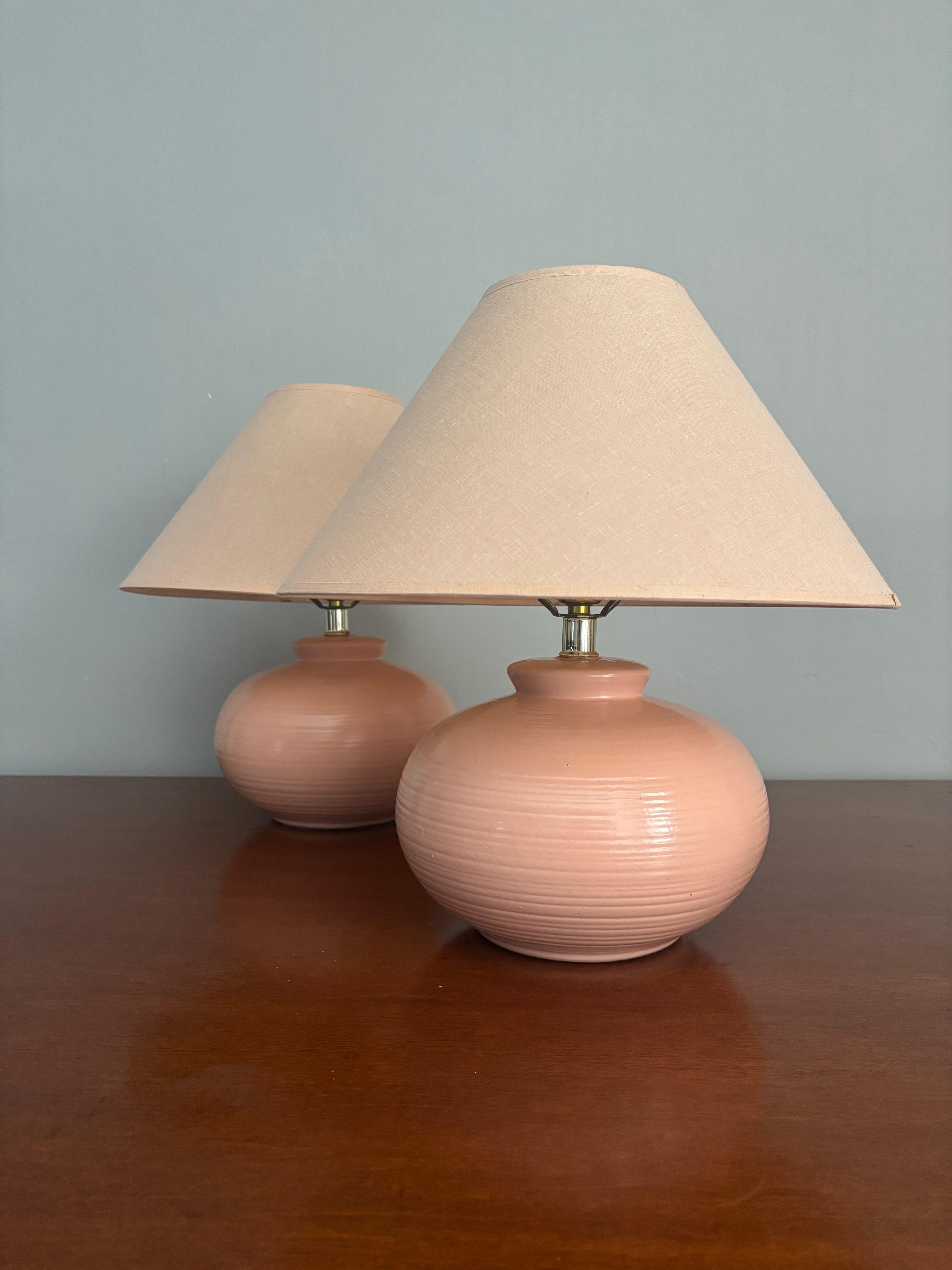 Paire de lampes de table en céramique vintage du milieu du siècle dernier. Une forme et une taille mignonnes, chics et amusantes. Rose saumoné doux avec un corps large et une texture céramique classique. De petite taille tout en diffusant une bonne