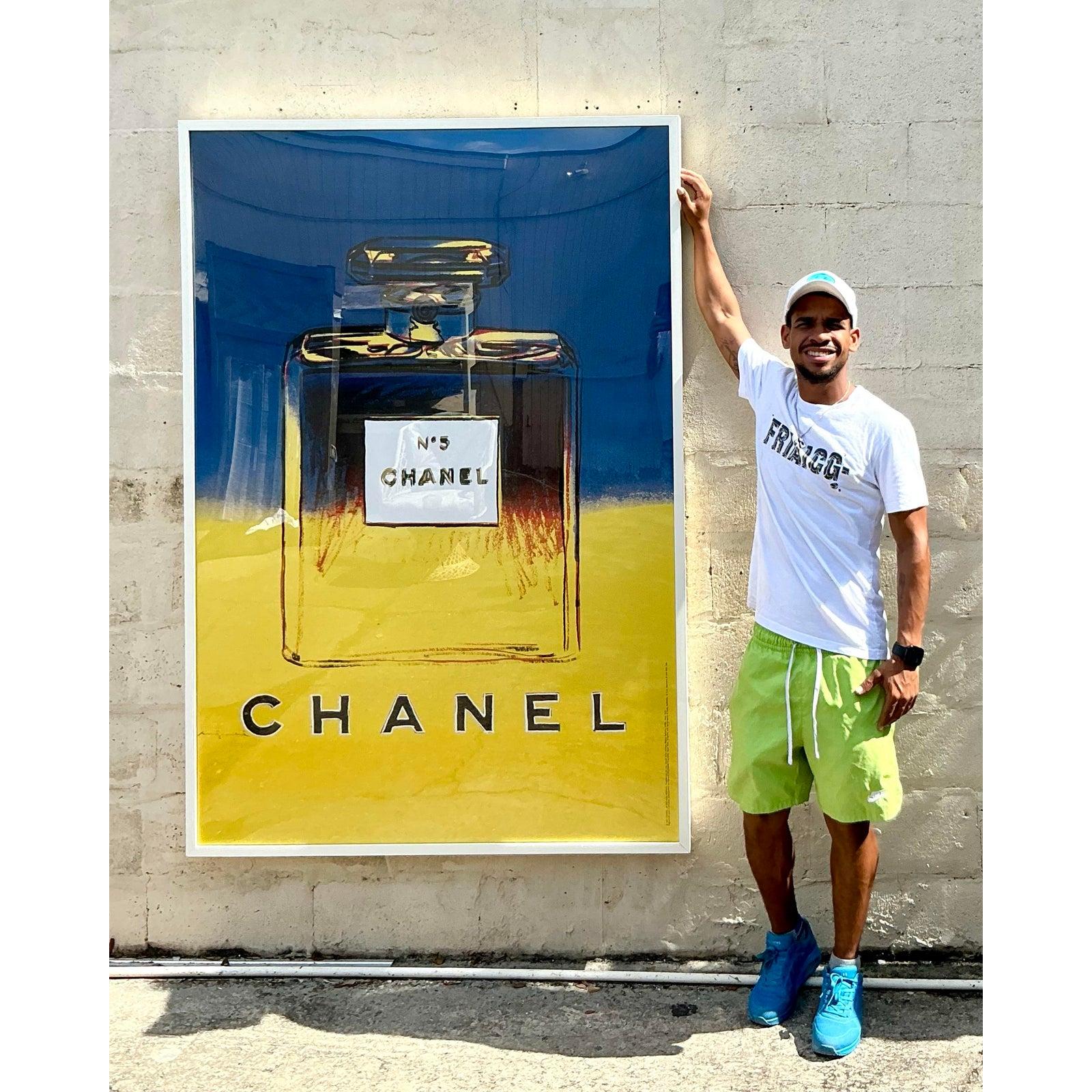 Fai una dichiarazione indimenticabile con questo monumentale poster pubblicitario incorniciato con l'iconica interpretazione Pop Art di Andy Warhol del flacone del profumo Chanel n°5. Questo pezzo di grande impatto visivo cattura la collisione tra
