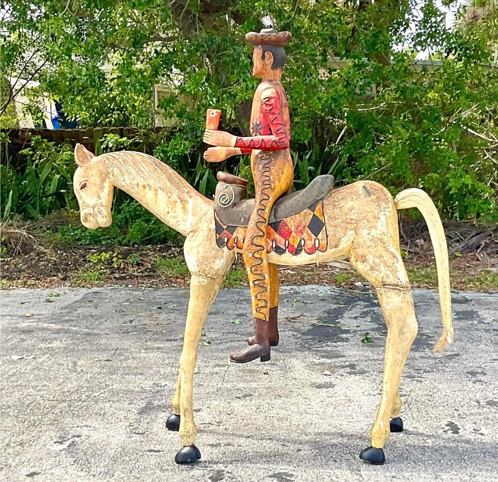 Bring a sense of adventure to your decor with this Vintage Boho monumental carved horse and rider. With intricate detailing and a bold presence, this piece embodies the spirit of American artistry, making it a captivating centerpiece for any room.