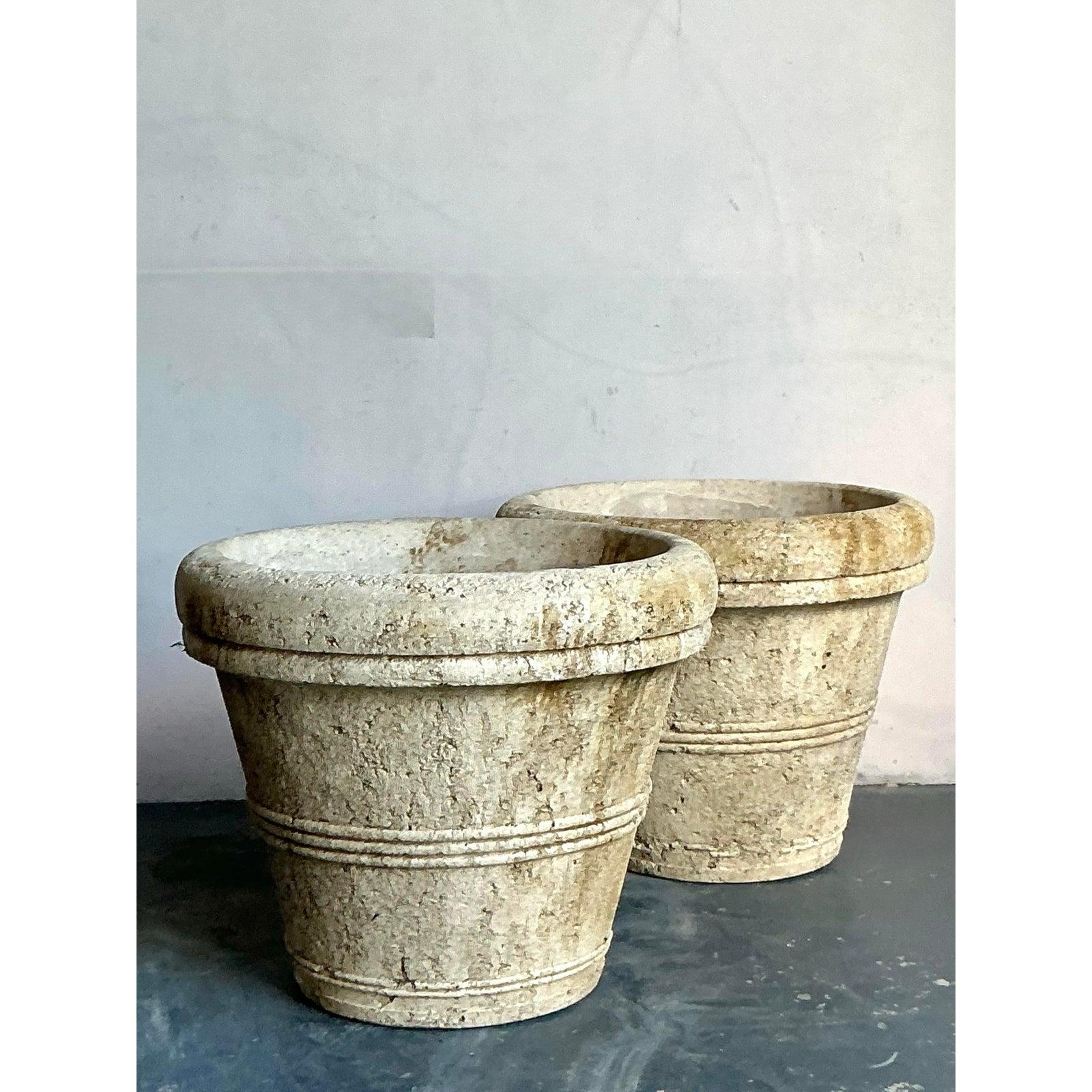 This impressive pair of large, traditional planters provides instant historical character and architectural weight to any exterior space. Crafted from rough-cast concrete, the vessels feature a classic, tapered silhouette accented by subtle banded