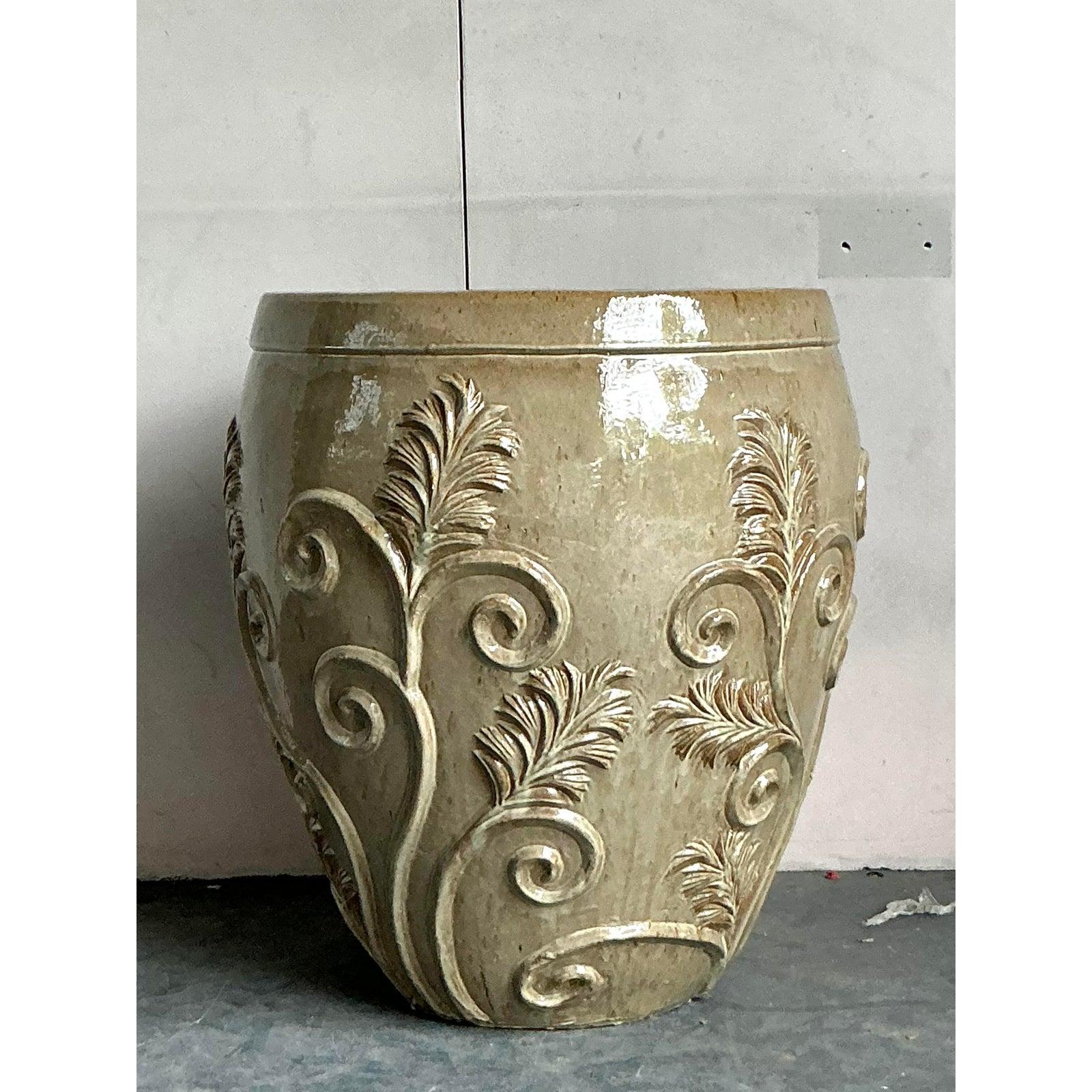 Ancrez votre oasis d'intérieur ou de jardin avec l'élégance sculpturale de cette jardinière monumentale en céramique émaillée. Sa forme substantielle et classique est ornée d'un exquis travail en relief appliqué à la main, comprenant des panaches