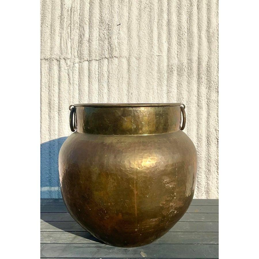 Elegia l'arredamento della tua casa con questa splendida urna vintage in ottone martellato, un pezzo senza tempo che emana eleganza e maestria. Caratterizzata da un design monumentale, quest'urna presenta una splendida texture martellata a mano e