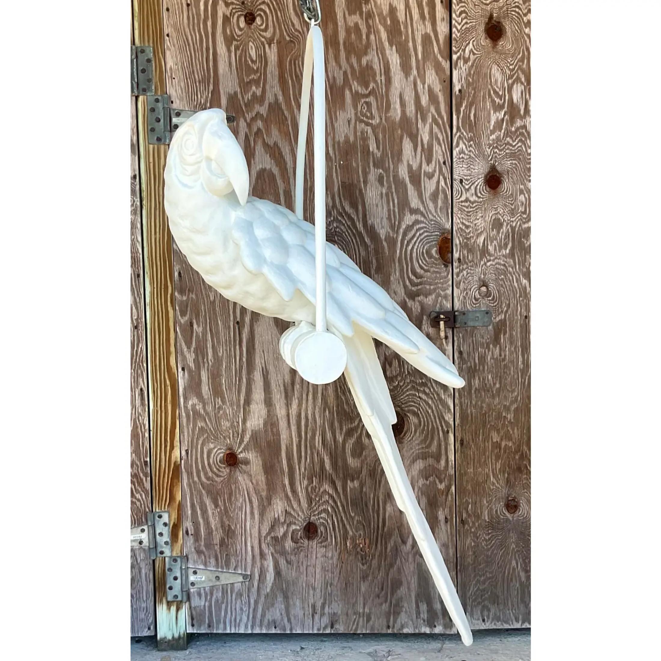 Vintage Boho monumental bird. A brilliant parrot hanging on a perch. Plaster white over composite frame. Acquired from a Palm Beach estate