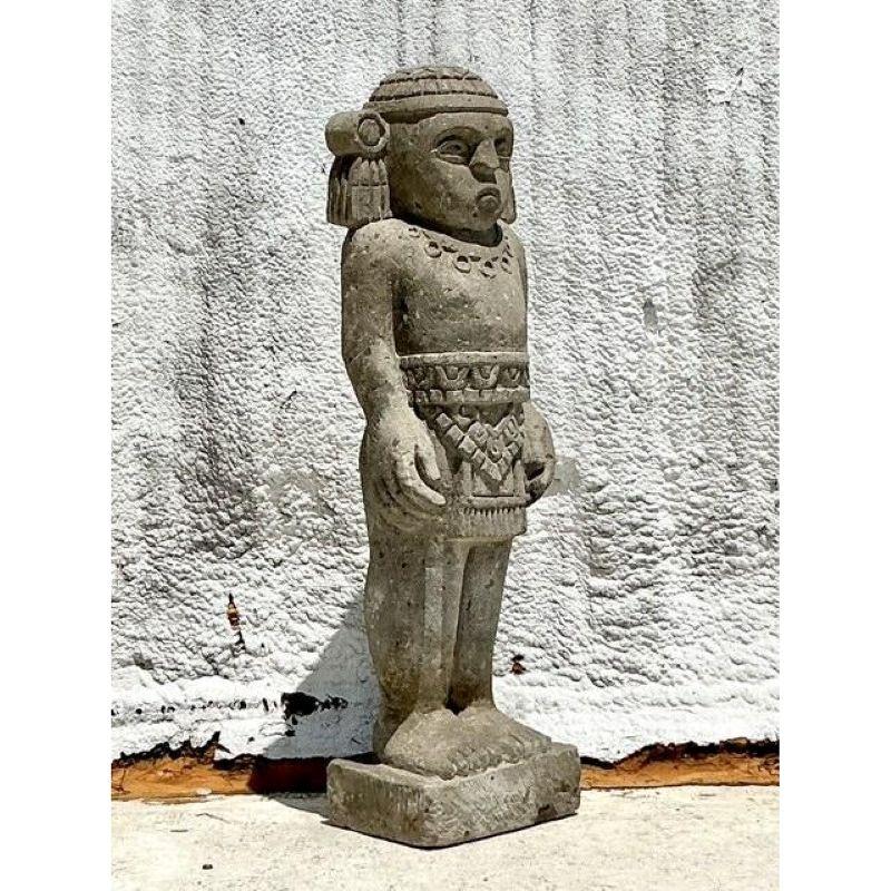 Immergi il tuo spazio nella ricca storia e nella potenza artistica di questa scultura monumentale boho vintage in pietra maya intagliata di un uomo. Questo straordinario pezzo, scolpito a mano in una pietra consistente, cattura lo spirito enigmatico