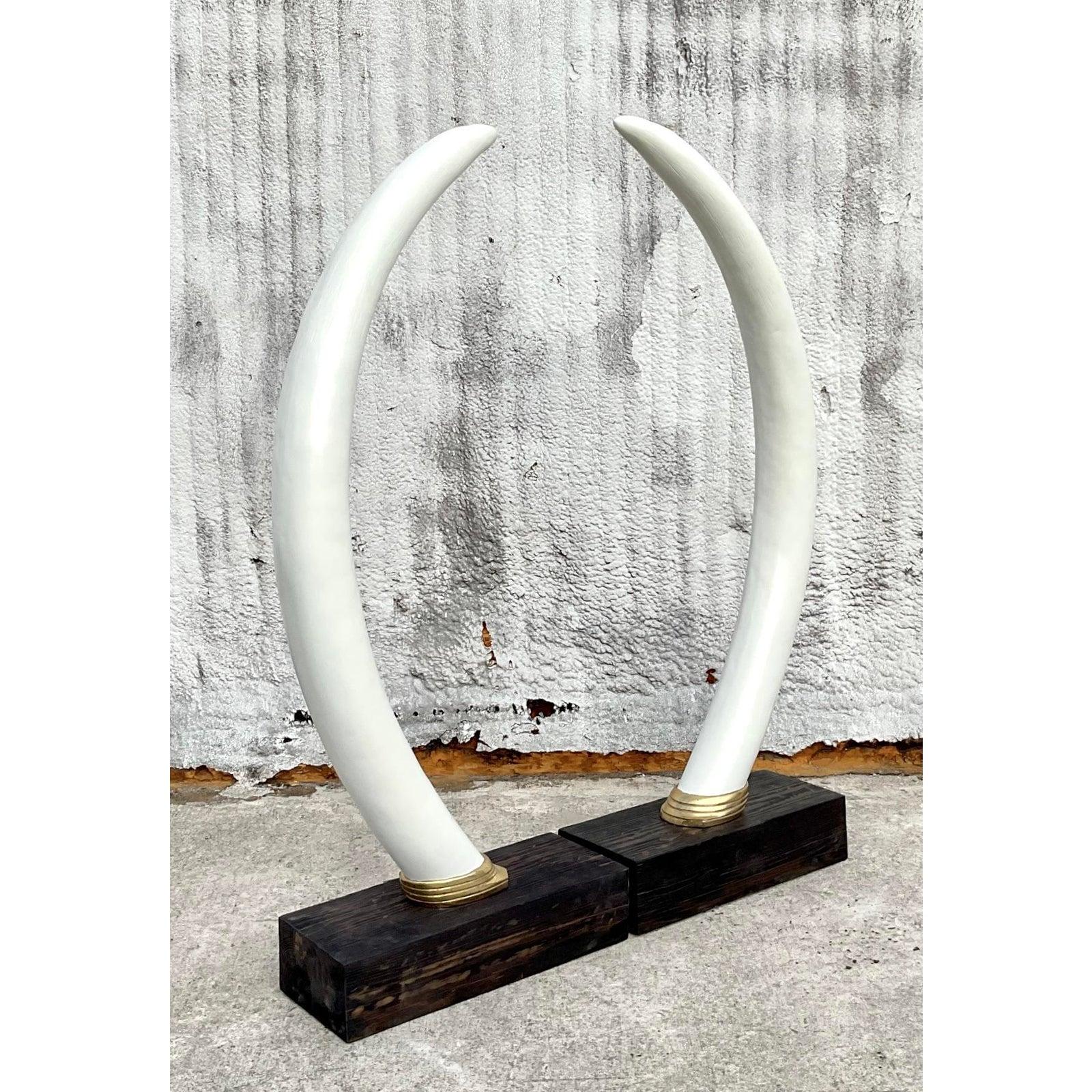 Make a grand statement with this striking pair of vintage monumental plaster elephant tusks, a breathtaking fusion of sculptural artistry and timeless elegance. Each tusk is gracefully curved, finished in a smooth, ivory-toned plaster, and anchored