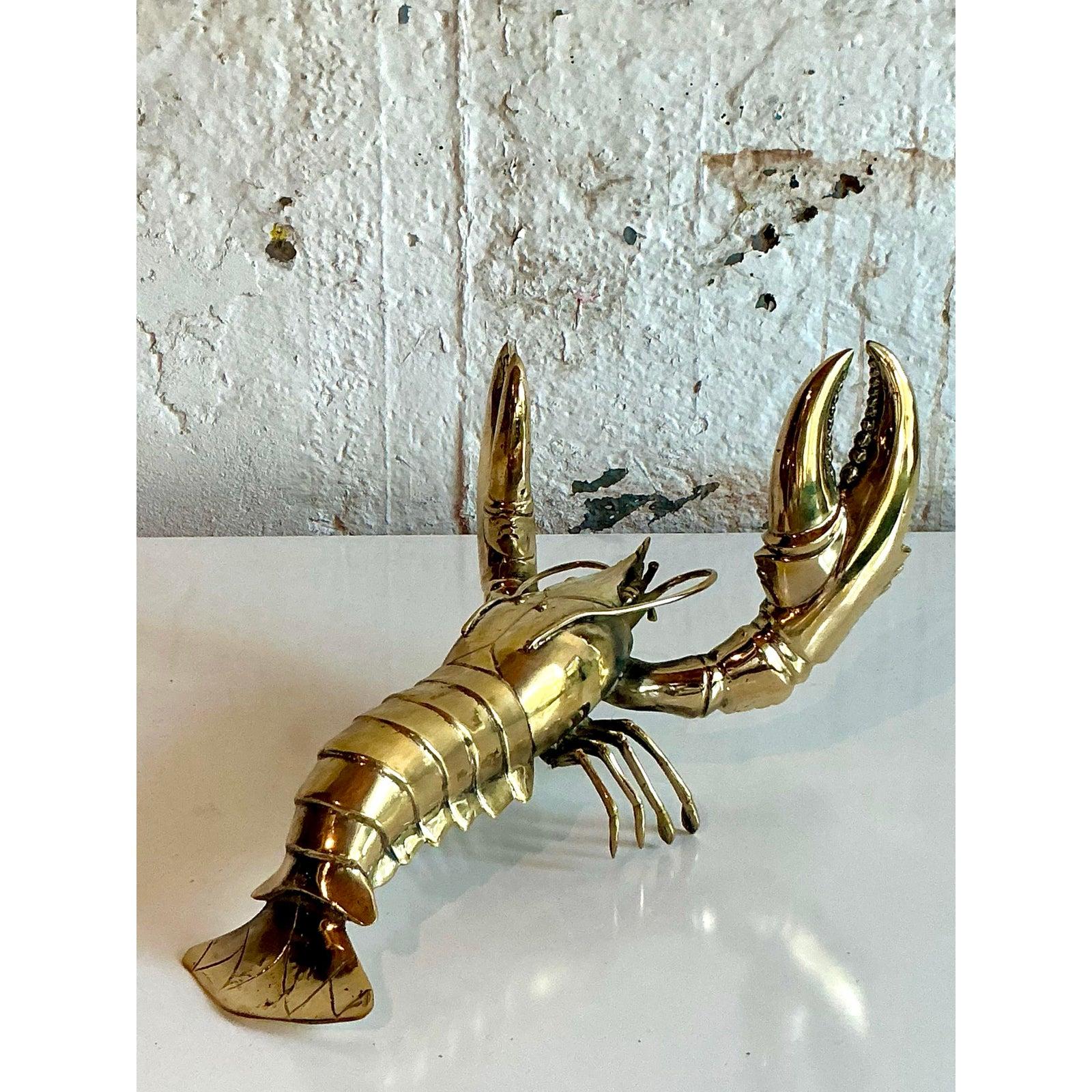 Fai una dichiarazione davvero unica con questa monumentale scultura di aragosta in ottone lucido vintage, un pezzo squisito che unisce un fascino stravagante a un design sofisticato. Realizzato in ottone massiccio, la sua superficie altamente lucida